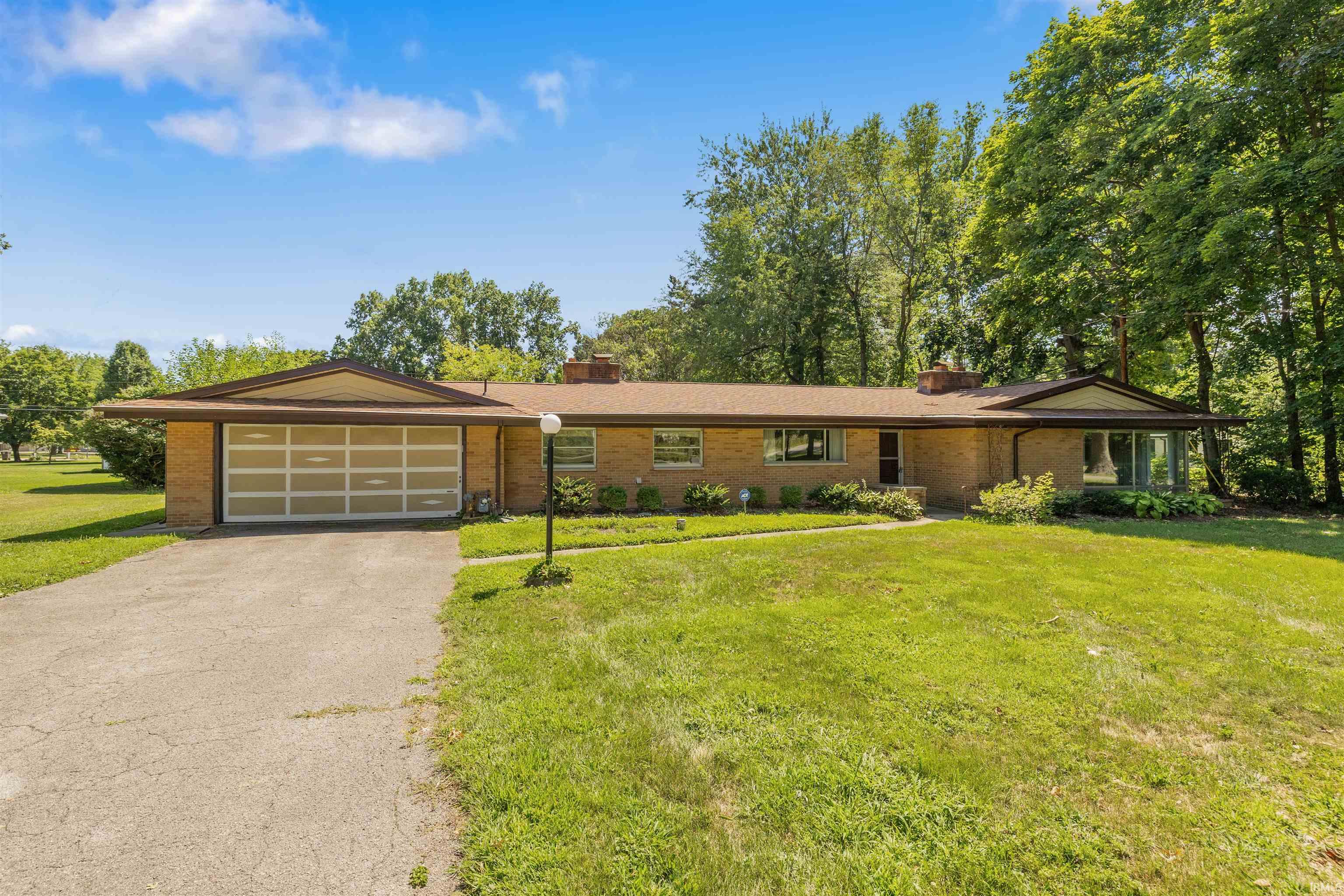Charming mid-century ranch home set on expansive, manicured grounds surrounded by mature landscaping