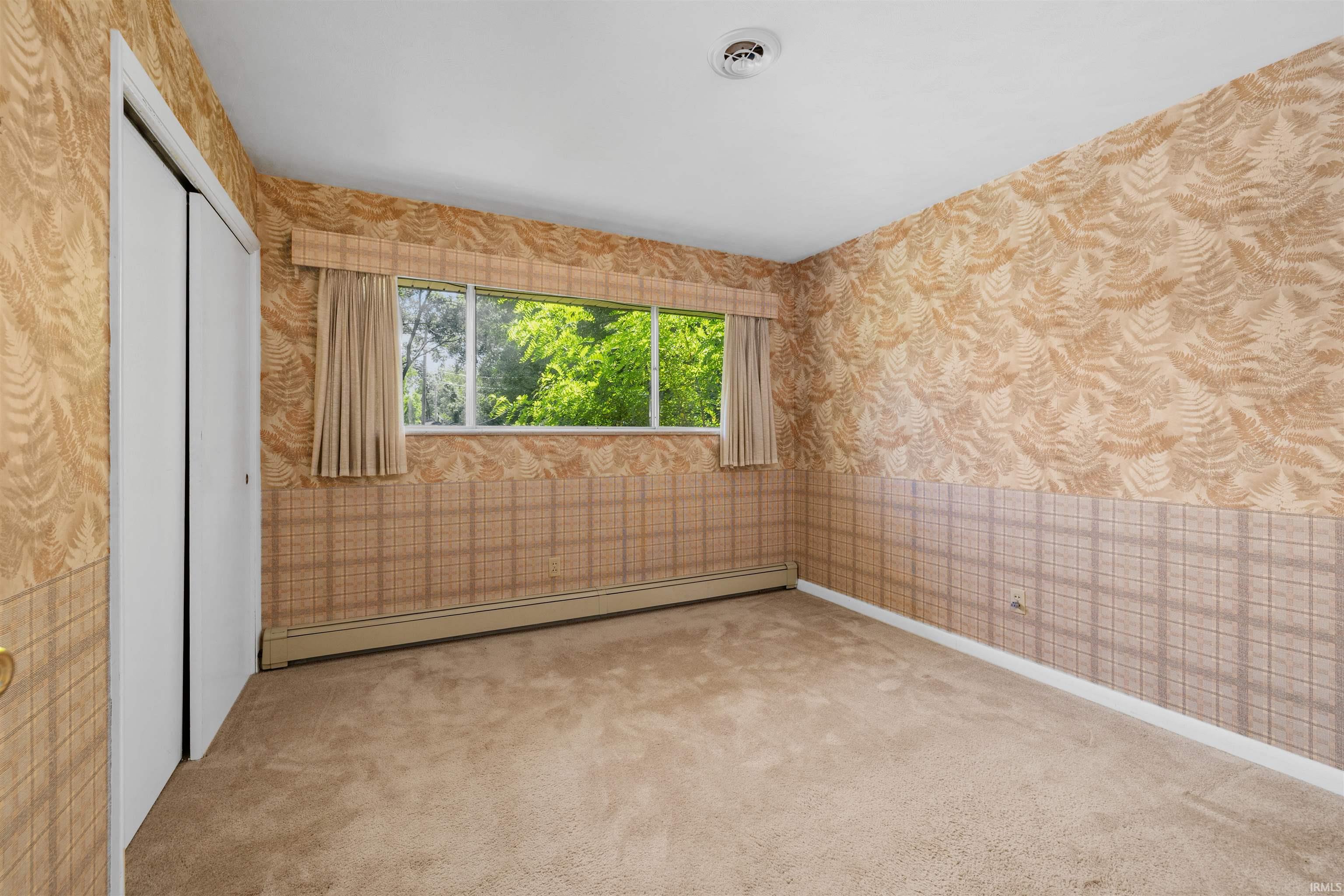 Spacious bedroom with large picture window flooding the room with natural light