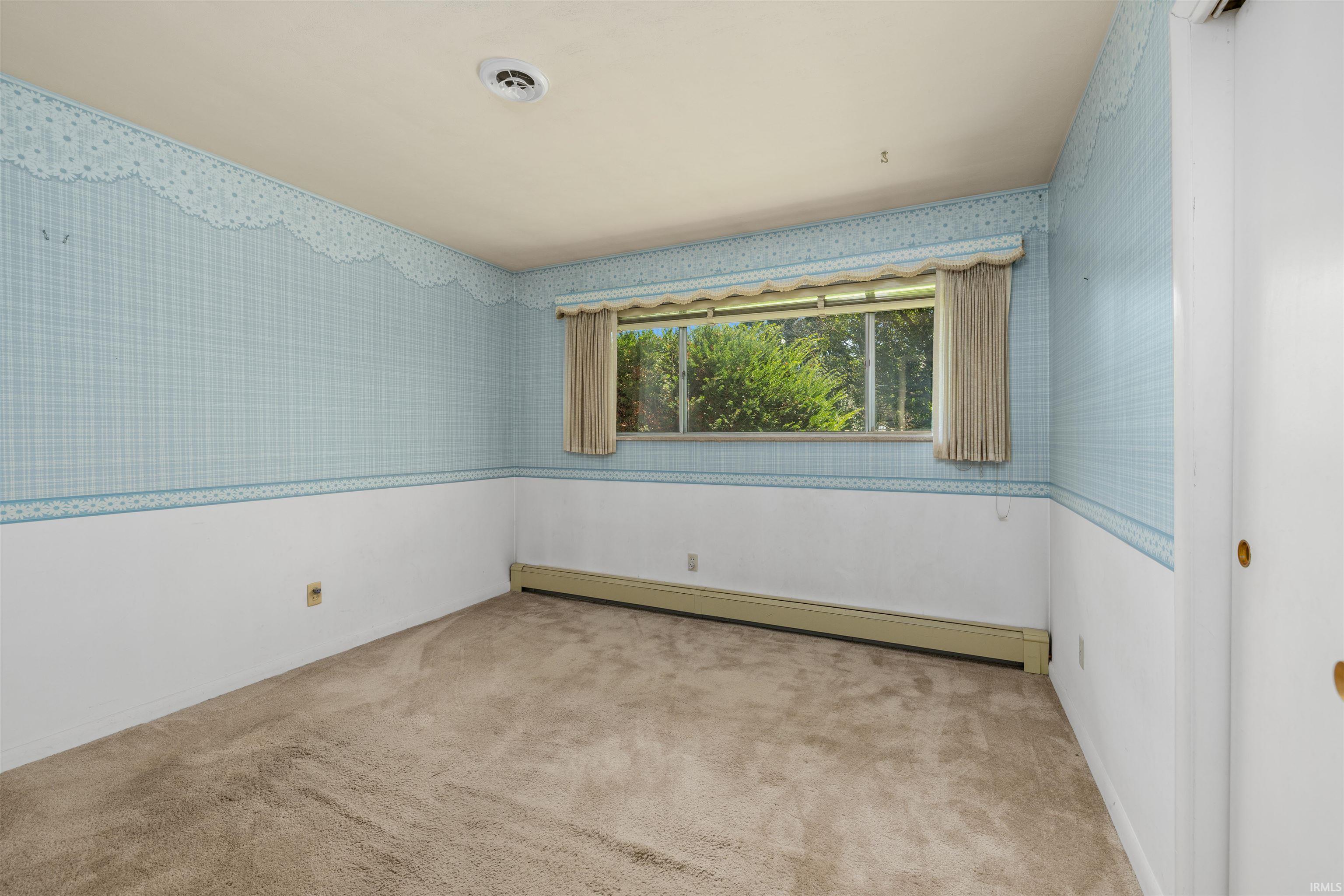 Wall-to-wall carpeting and a horizontal window with natural light