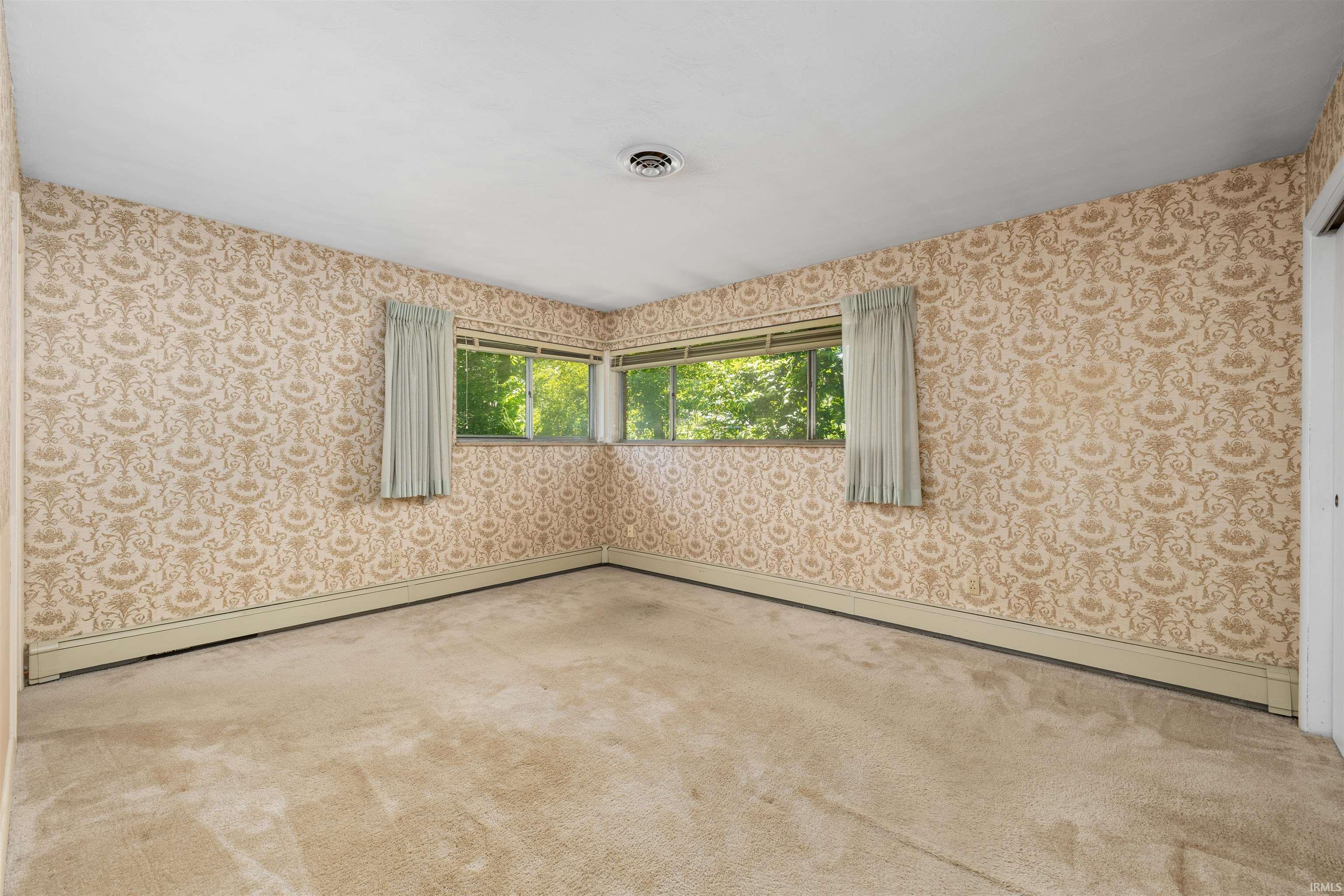 Spacious corner room bathed in natural light through multi-pane windows