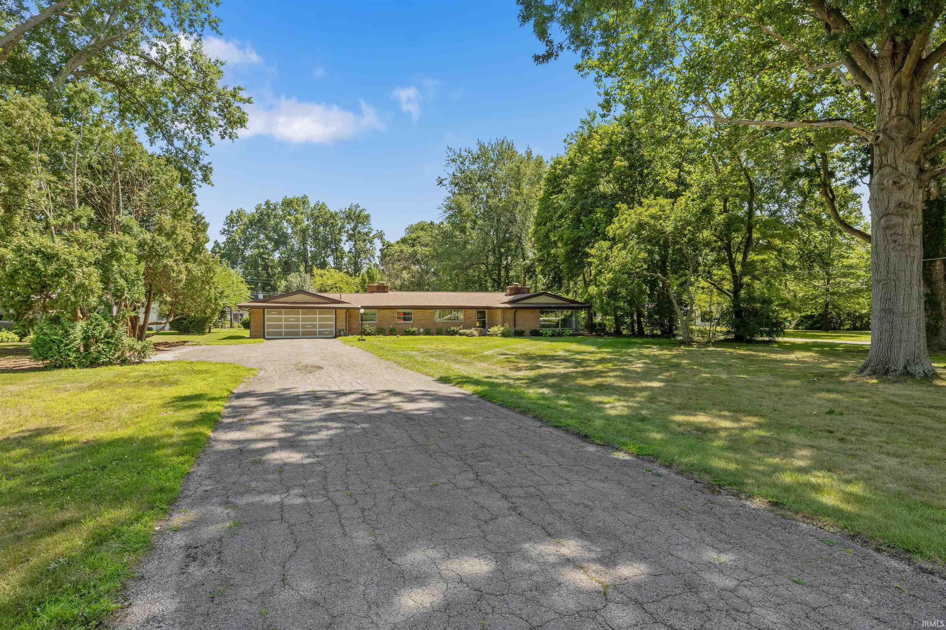 Brick ranch home situated on expansive grounds with mature landscaping