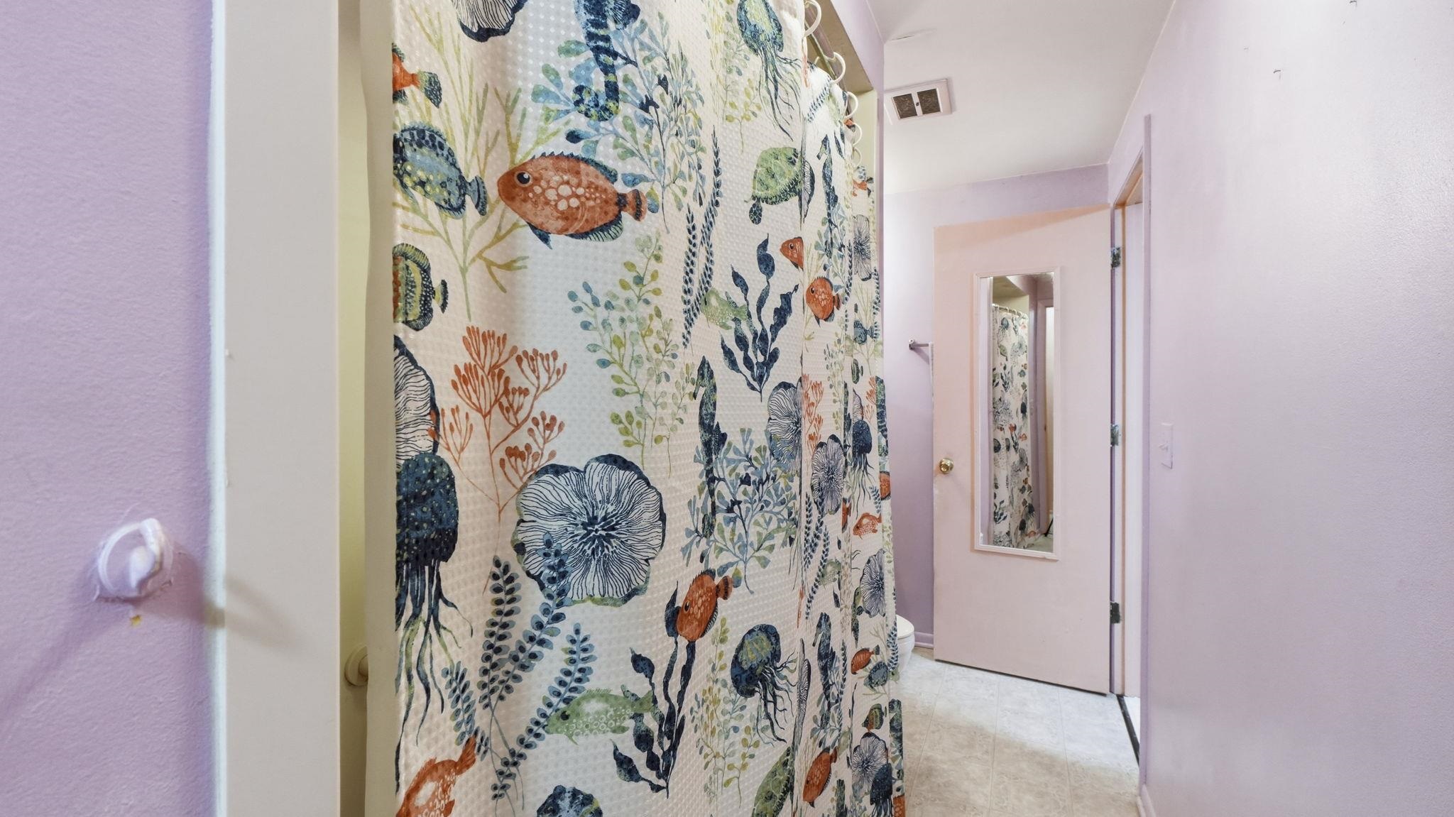 Hallway with custom botanical wallcovering featuring an intricate pattern of coral, navy, and sage botanicals