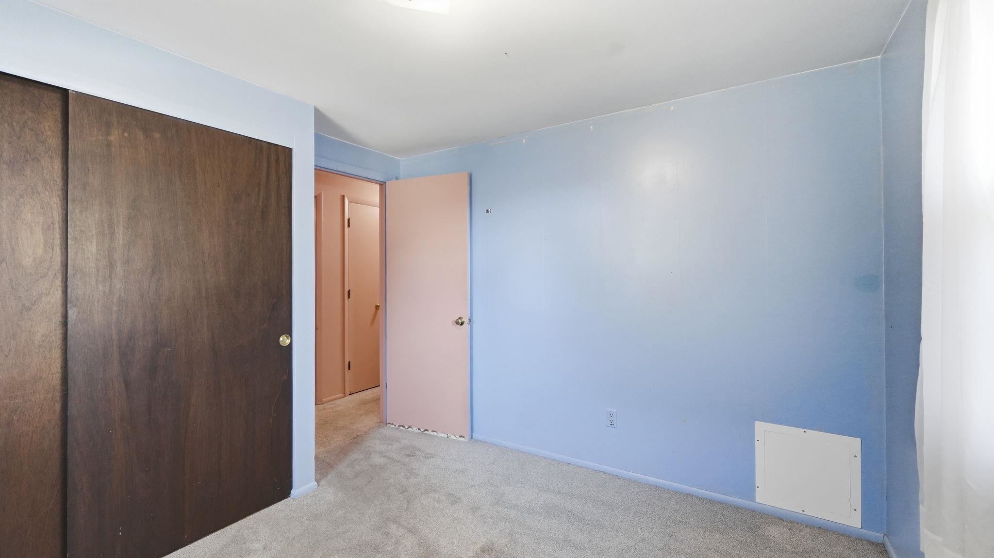 Versatile interior space featuring fresh blue wall finishes, polished concrete flooring, and multiple solid-core doors with wood-finish frames