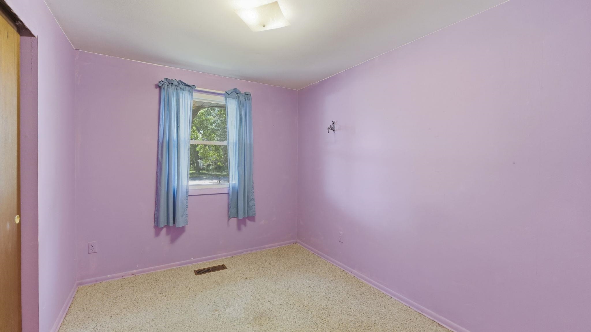 Room featuring wall-to-wall carpeting, a window with exterior views, and a ceiling-mounted light fixture