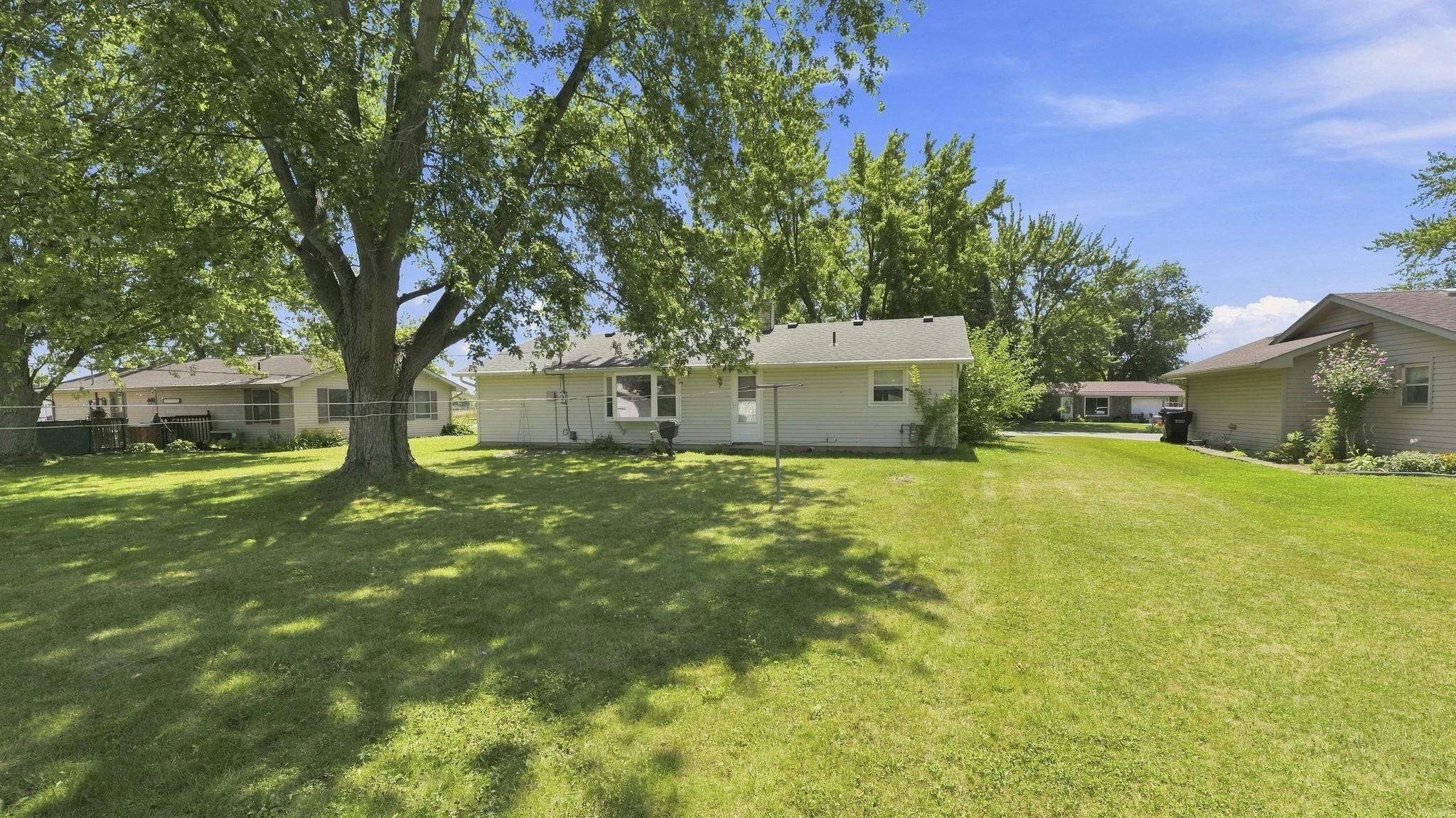 Expansive grounds featuring mature shade trees and lush, manicured lawn