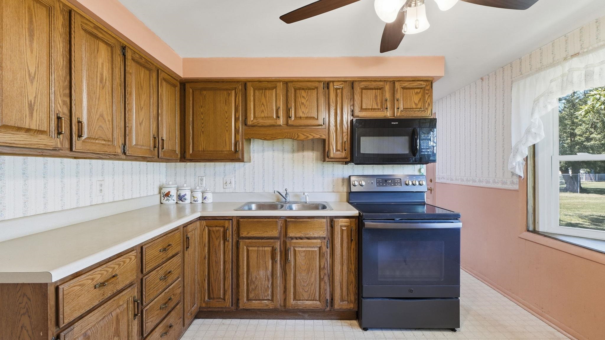 Warm wood cabinetry with traditional raised-panel doors and hardware accents frames this kitchen workspace