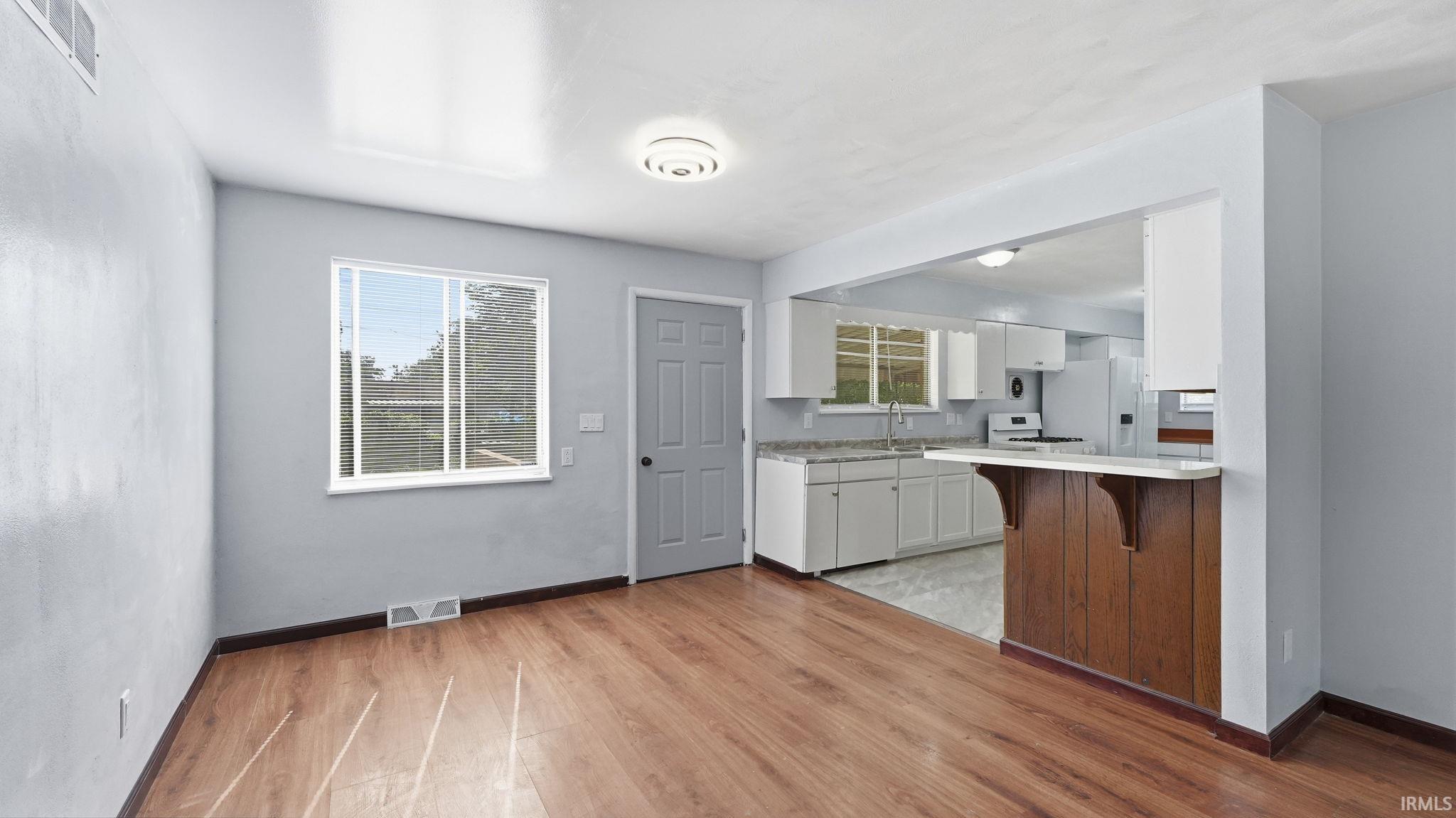 Open concept living space featuring wood-finish flooring and light gray walls