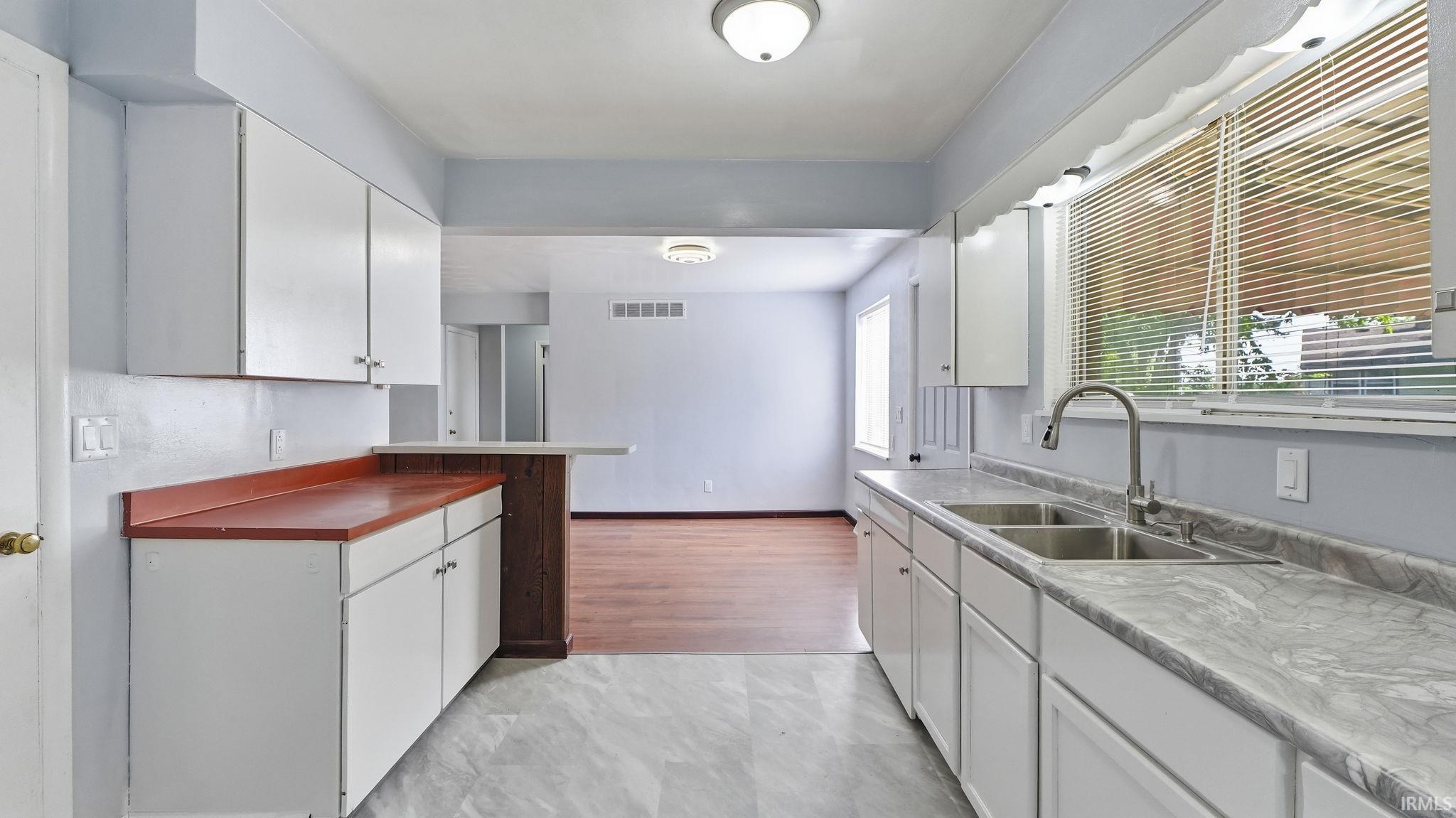 Kitchen featuring white cabinetry and light-toned flooring