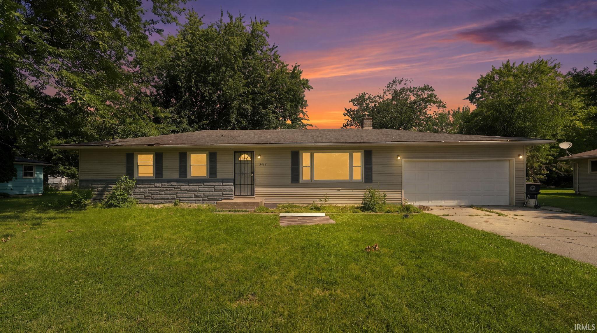 Ranch-style residence featuring horizontal siding and a stone accent facade
