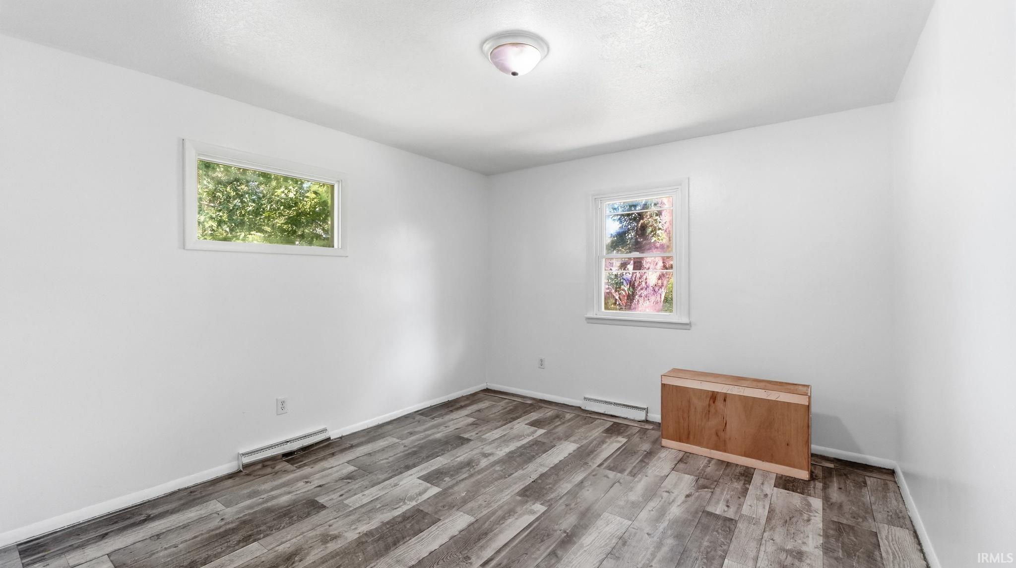 Neutral white walls complement the wood-finish flooring