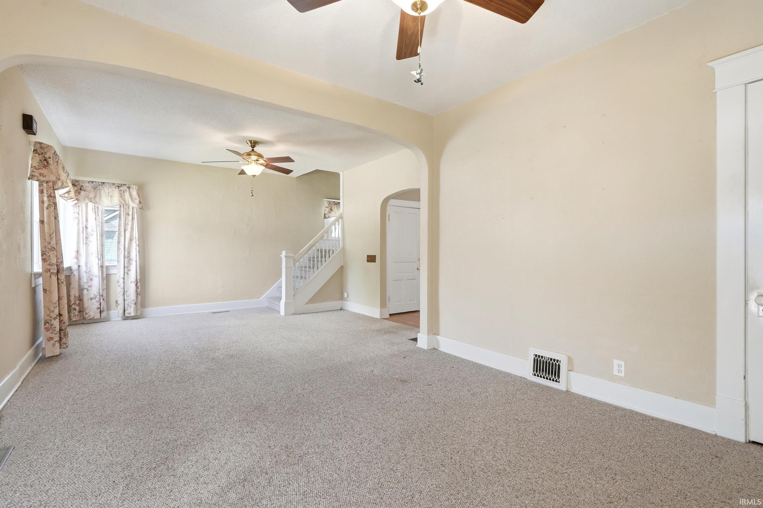 Carpeted living area with light-toned walls and white trim