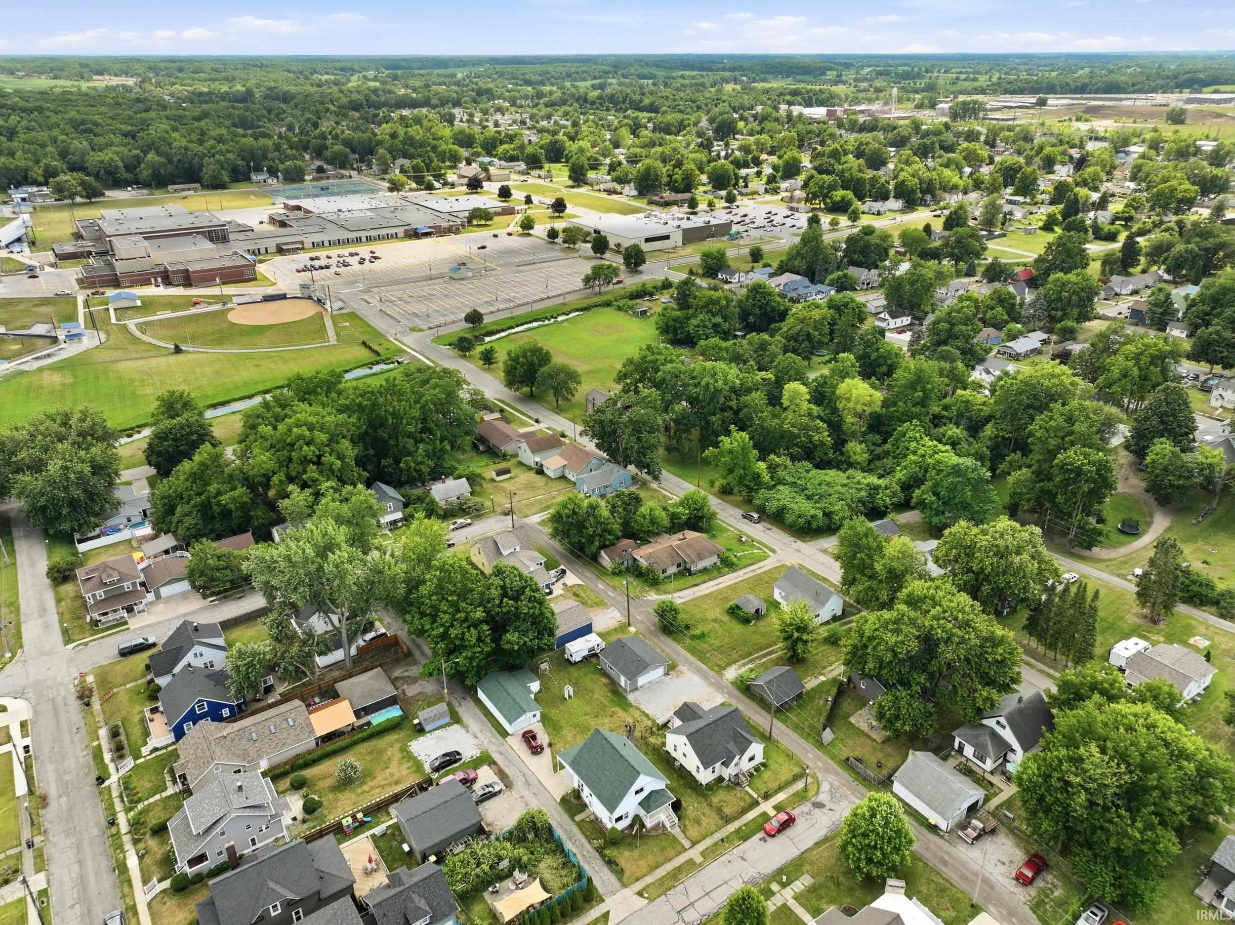 Aerial perspective showcasing a residential neighborhood with mature trees and green spaces
