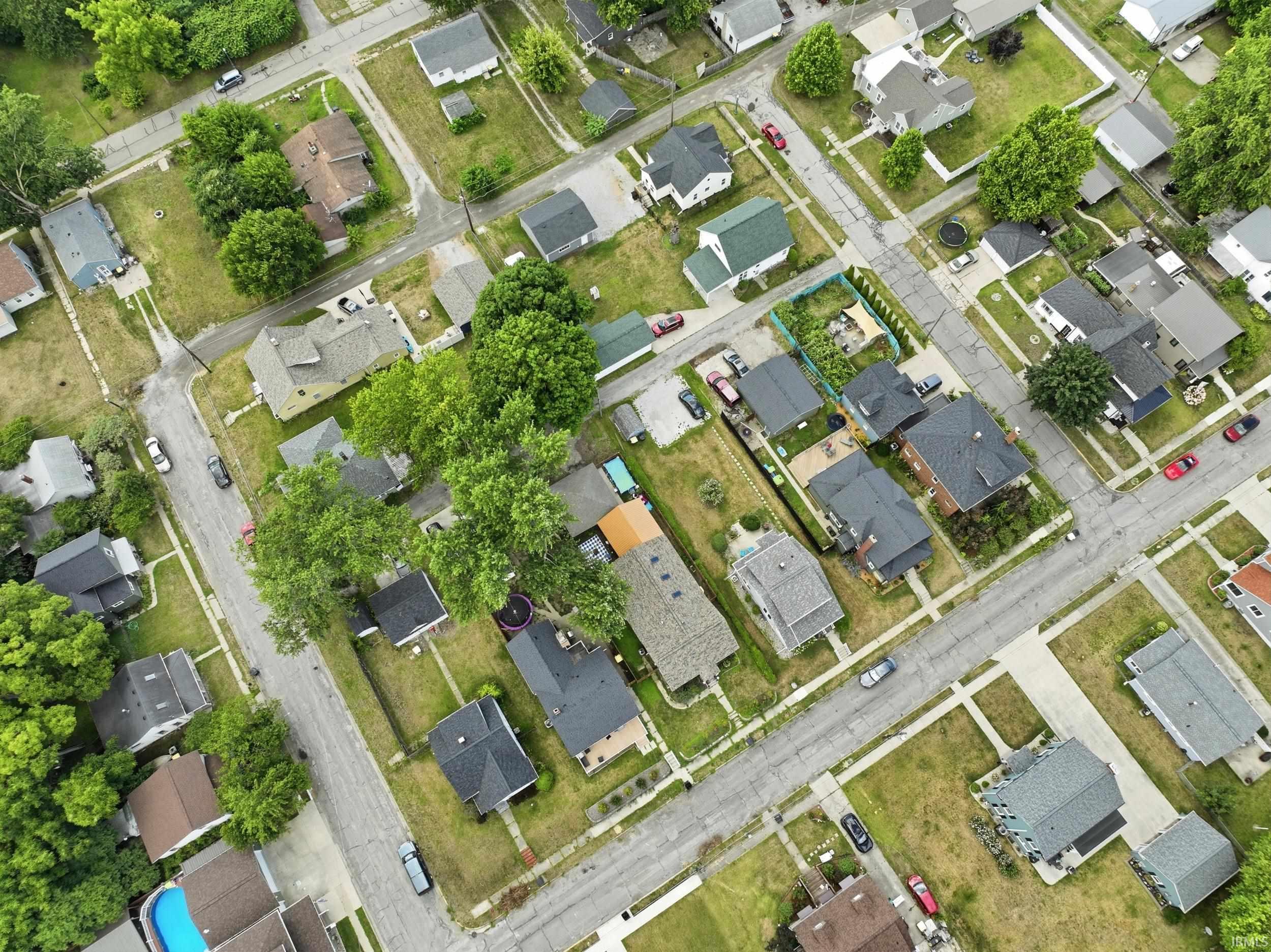 Residential neighborhood featuring a grid street pattern, mature trees, individual homes, and paved sidewalks