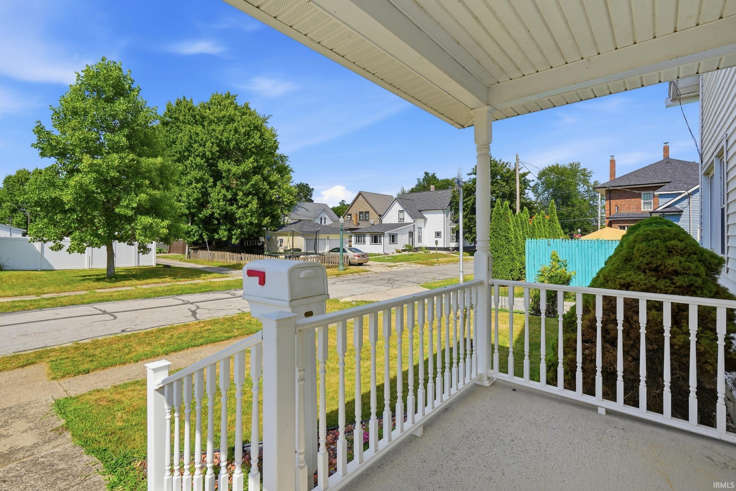 Front porch featuring white railings and a white mailbox
