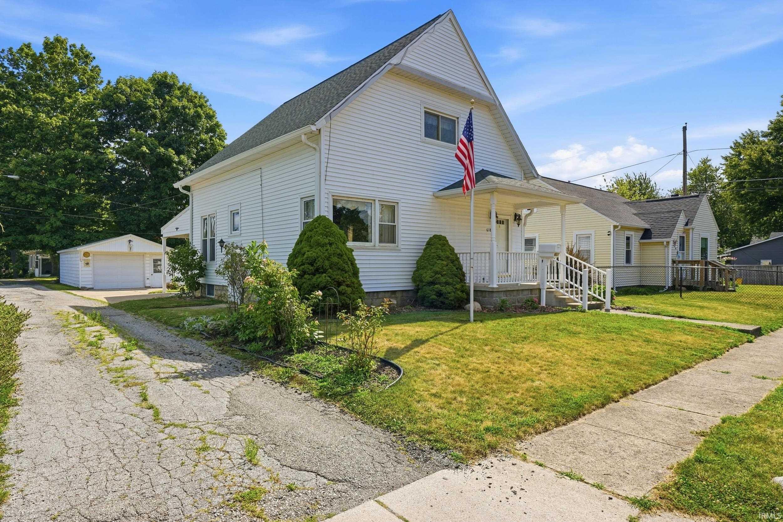 White siding residence with a covered porch featuring white railings