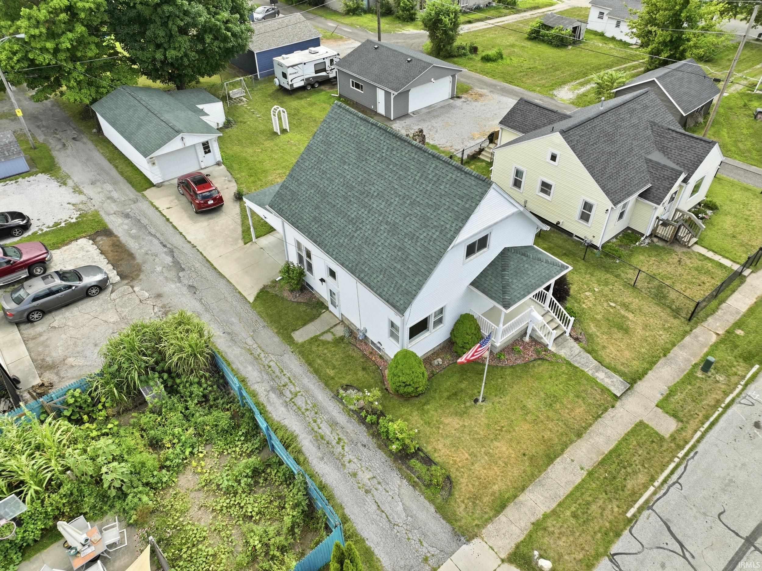 Two-story residence featuring a covered front porch and a green shingle roof