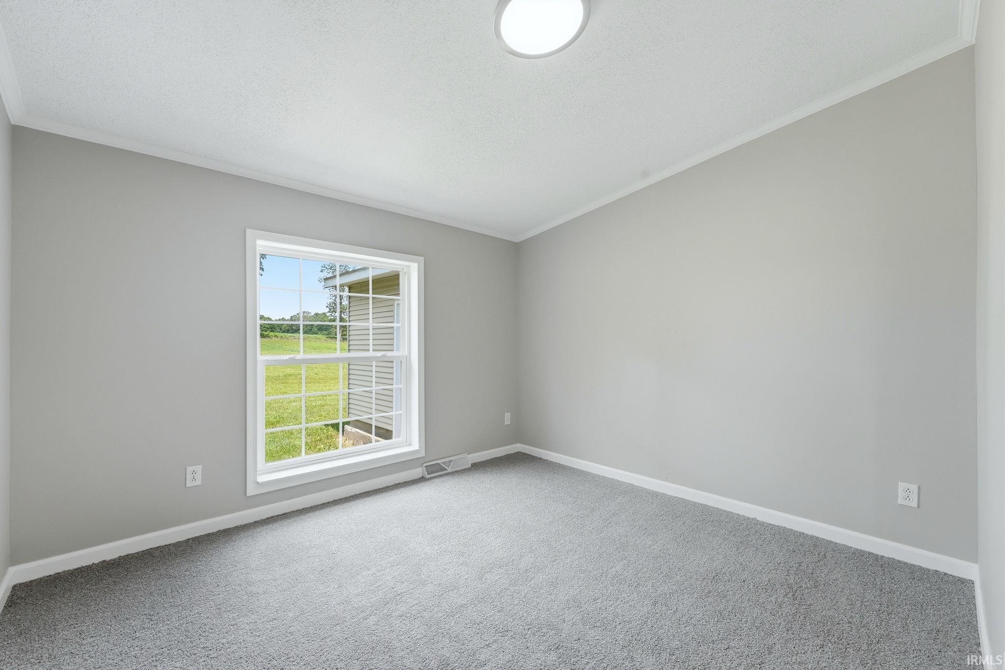 Bedroom featuring light gray wall paint, gray carpeting, a single window with white trim, white baseboards, and a flush-mount ceiling light fixture