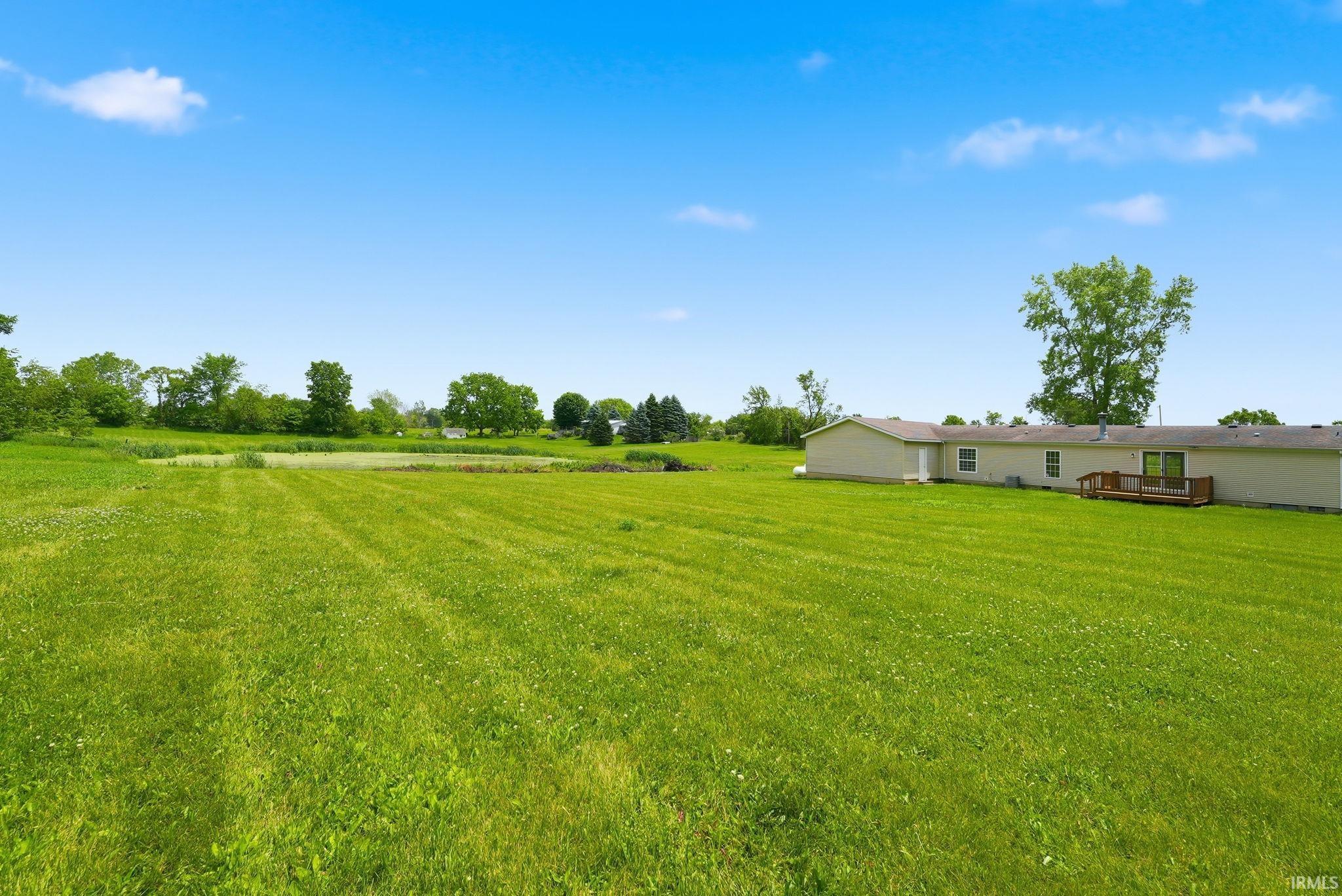 Expansive green lawn with a pond feature