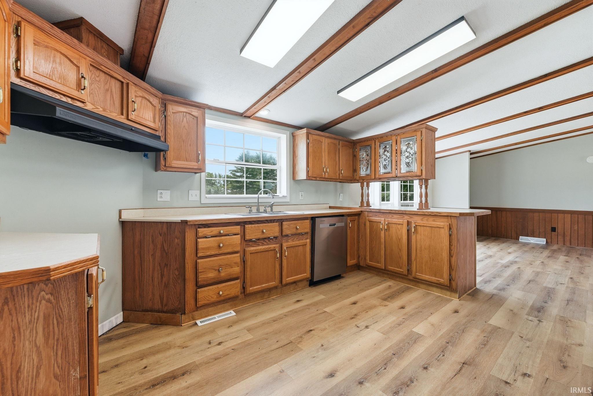 Kitchen featuring wood-finish cabinetry, light-toned countertops, and stainless steel appliances