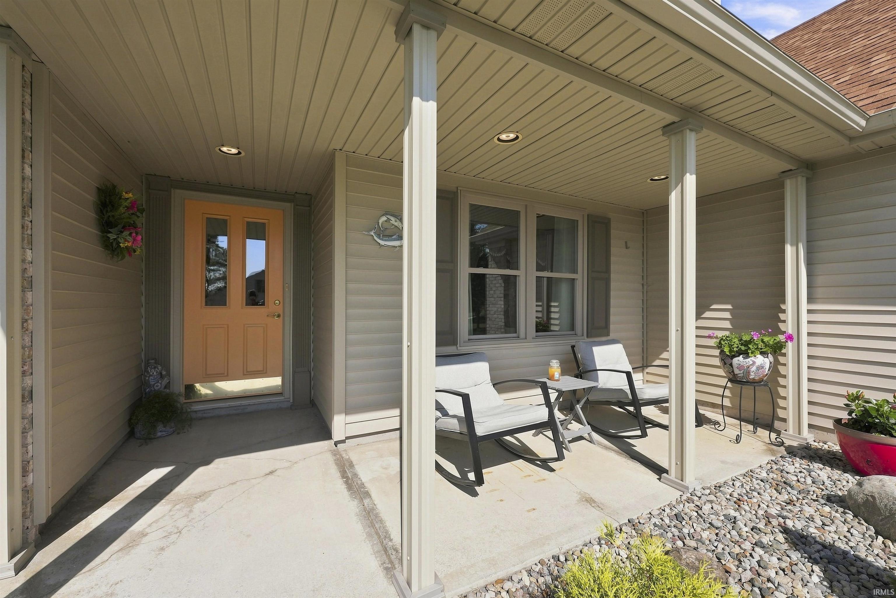 Covered front porch featuring recessed lighting, a paneled entry door with glass inserts, and horizontal siding