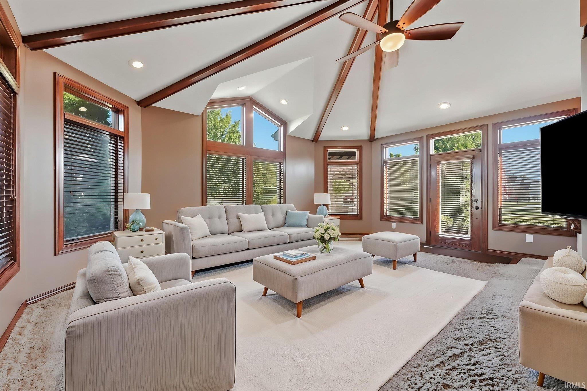 Vaulted ceiling with exposed wood beams and recessed lighting