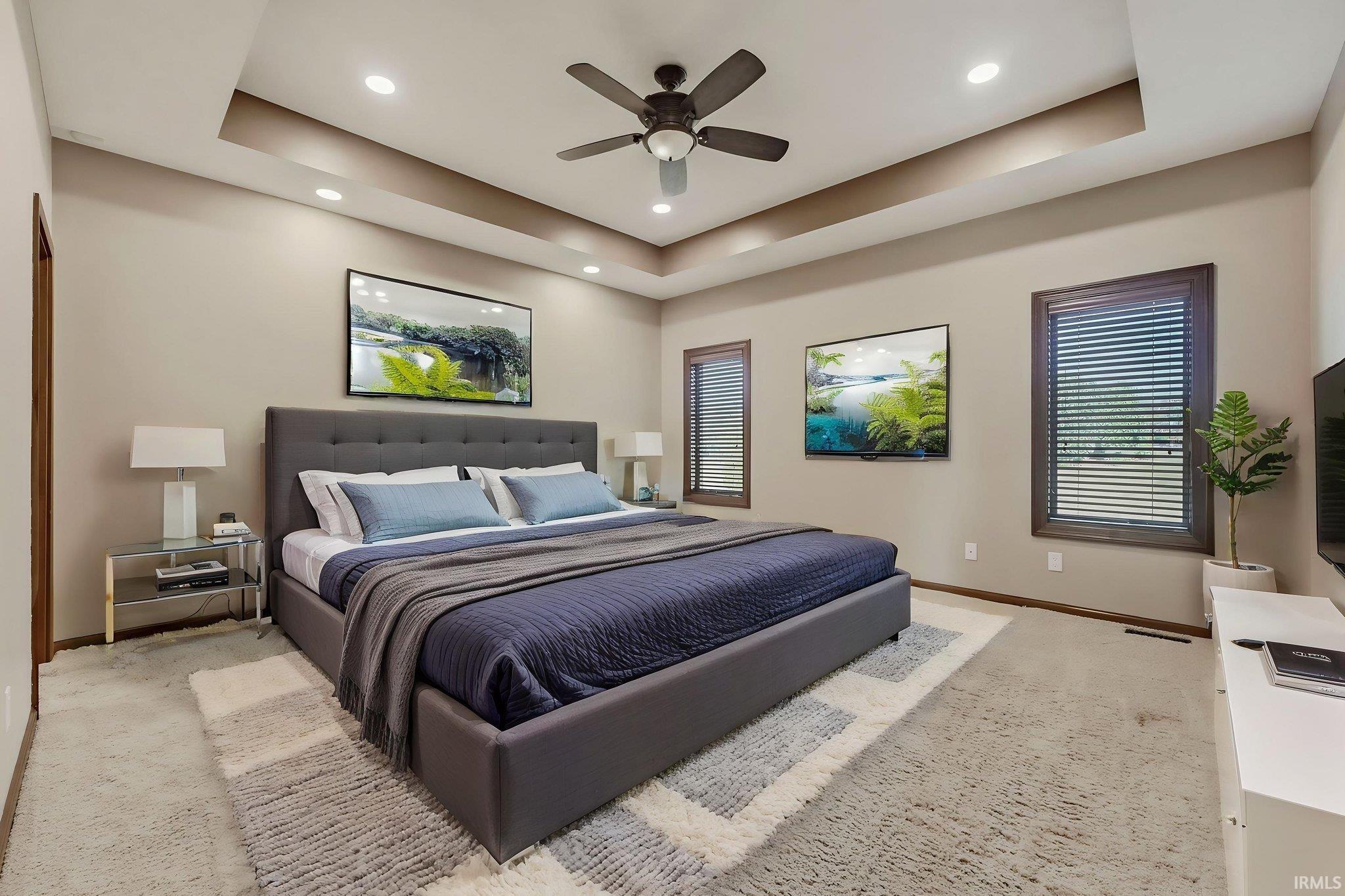 Recessed lighting illuminates a tray ceiling with a built-in ceiling fan