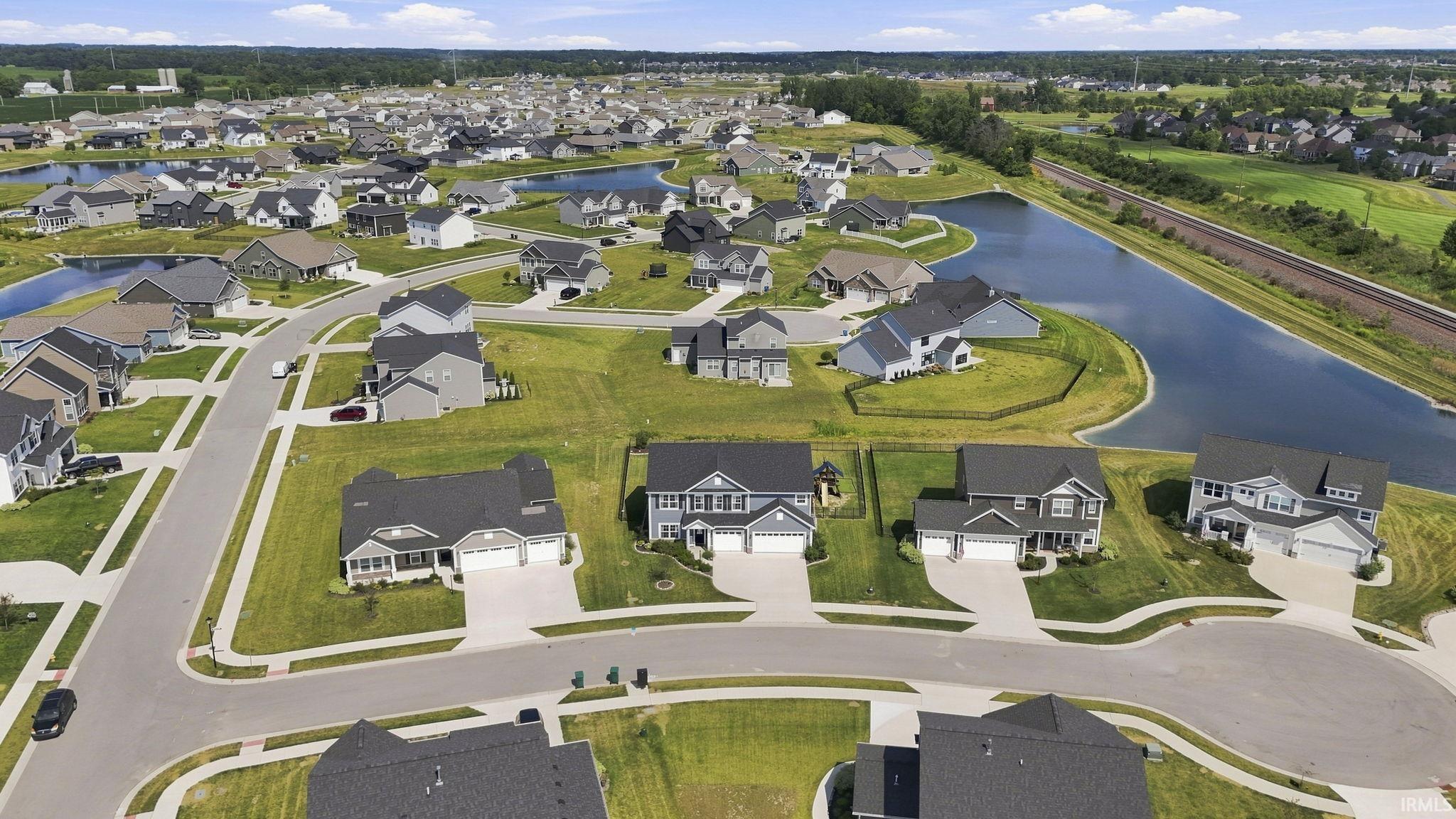 Prestigious planned community featuring elegant new construction homes with manicured lawns, curved cul-de-sac streetscapes, and integrated water features