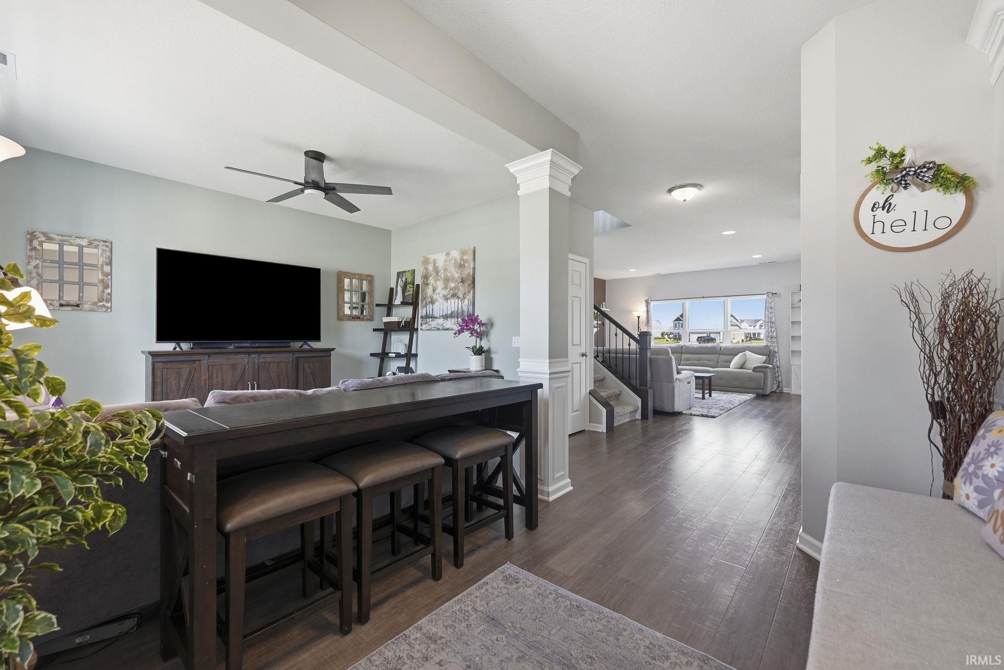 Expansive open-concept living area featuring wood-finish flooring, a contemporary ceiling fan, and recessed lighting