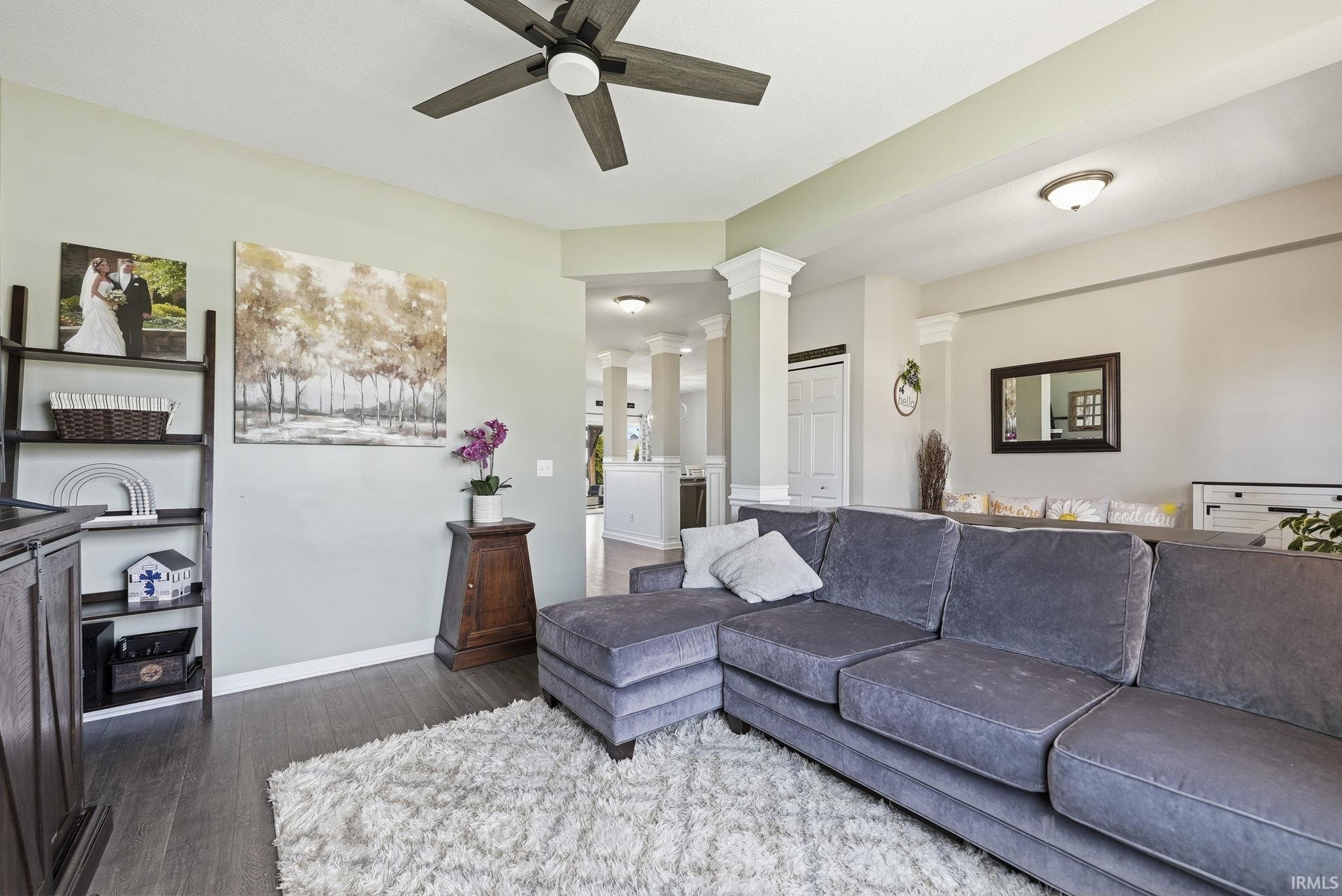 Living area featuring wood-finish flooring, a ceiling fan with light fixture, and recessed lighting