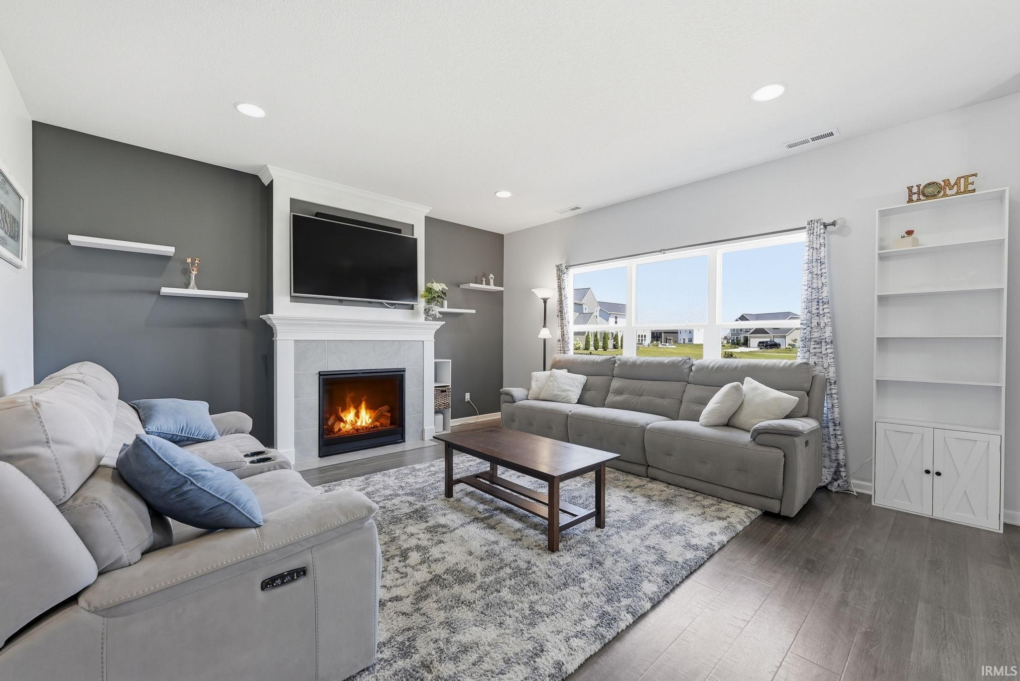 Modern living room featuring a linear gas fireplace with white surround and built-in shelving, paired with comfortable seating arrangements