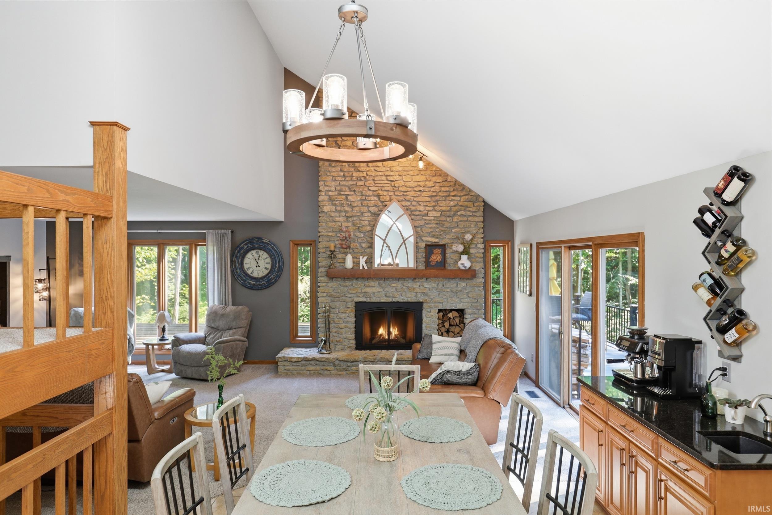Vaulted ceilings highlight a stone fireplace with a wood mantle