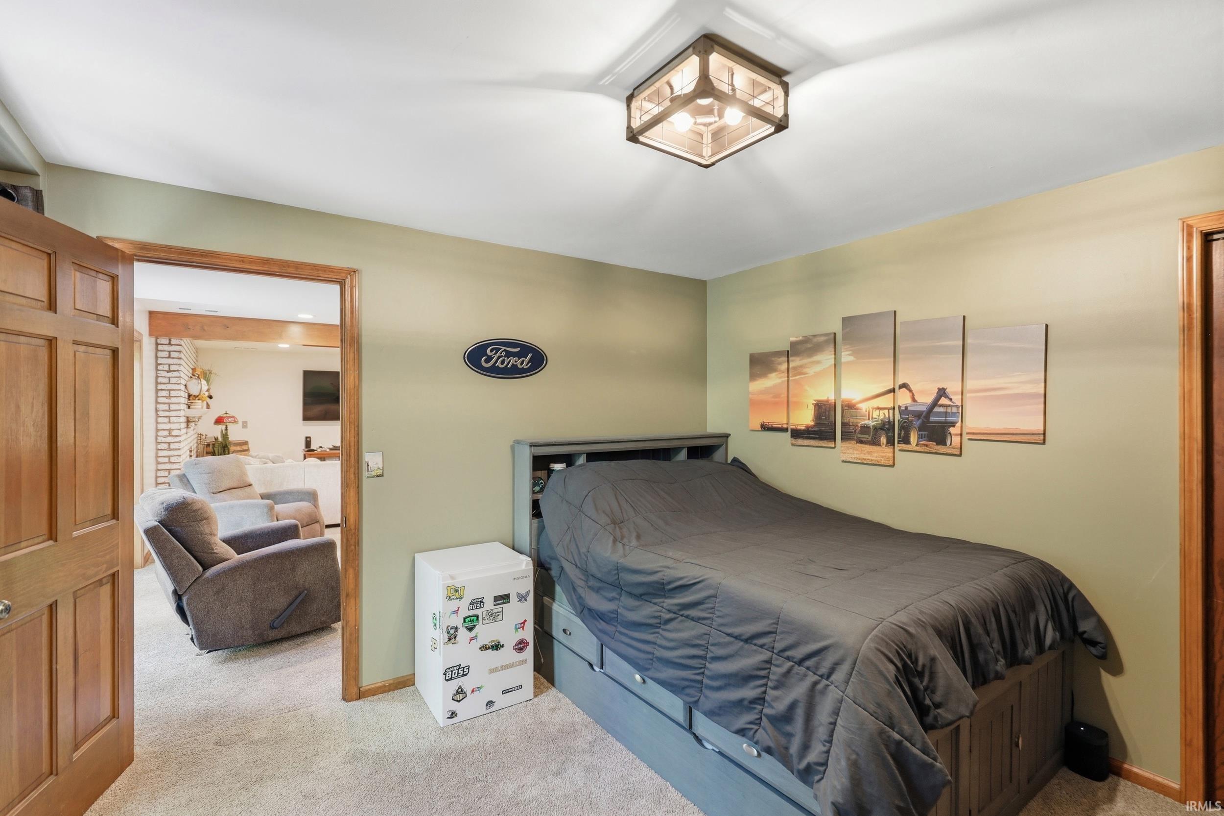Carpeted room with a wooden door frame, light green walls, and a flush mount ceiling light