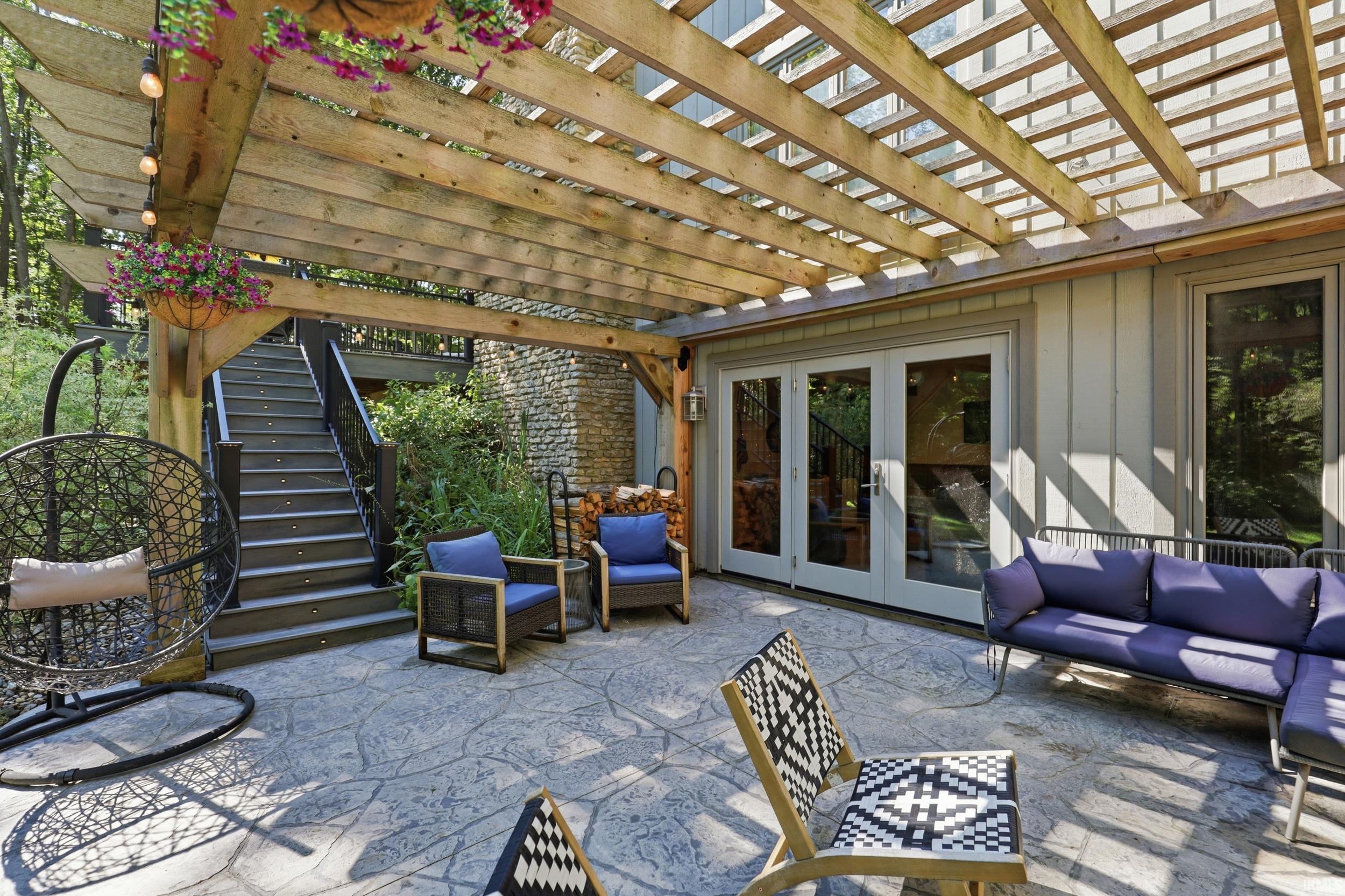 Expansive stamped concrete patio with a wooden pergola overhead