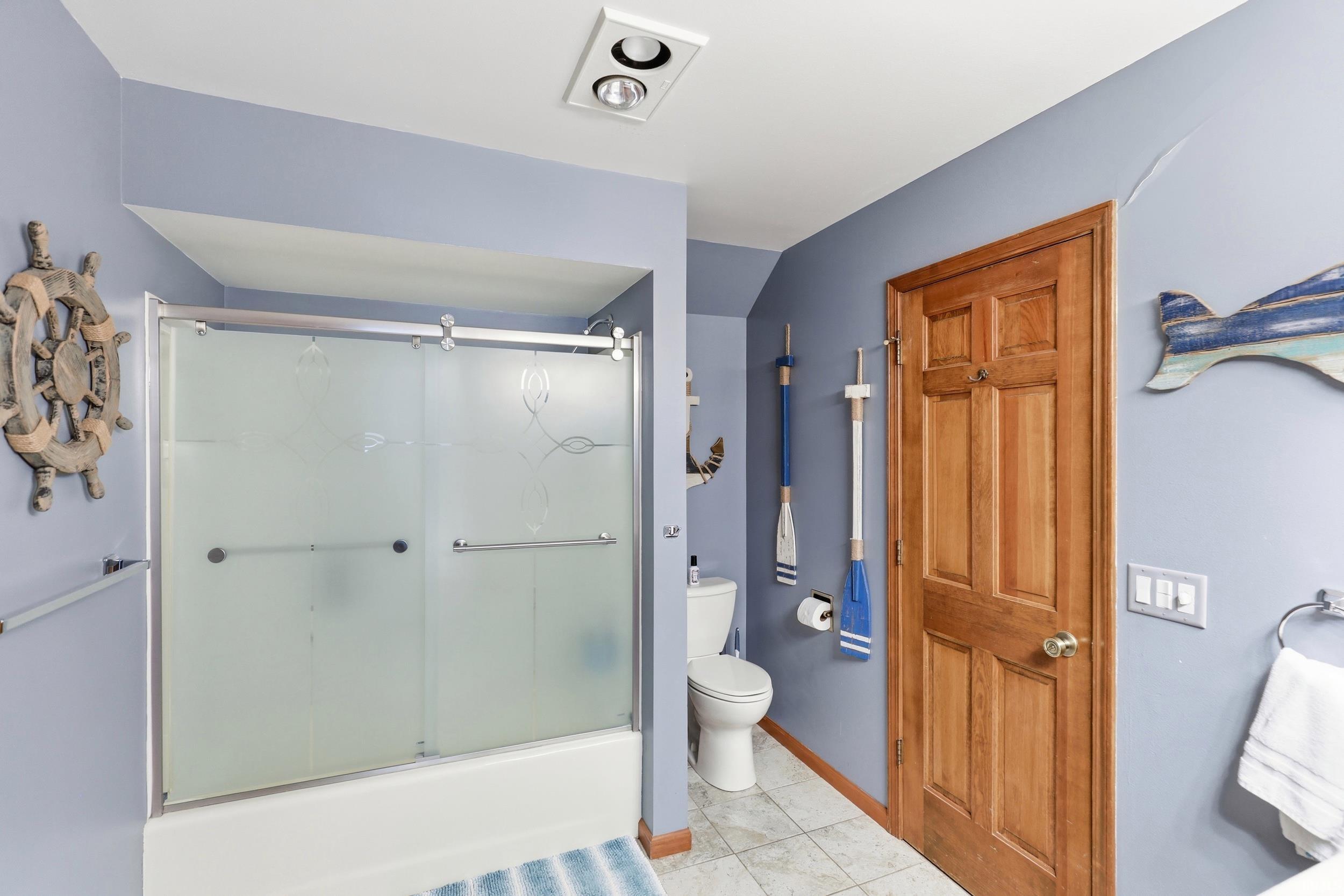 Bathtub with sliding frosted glass enclosure and integrated towel bars