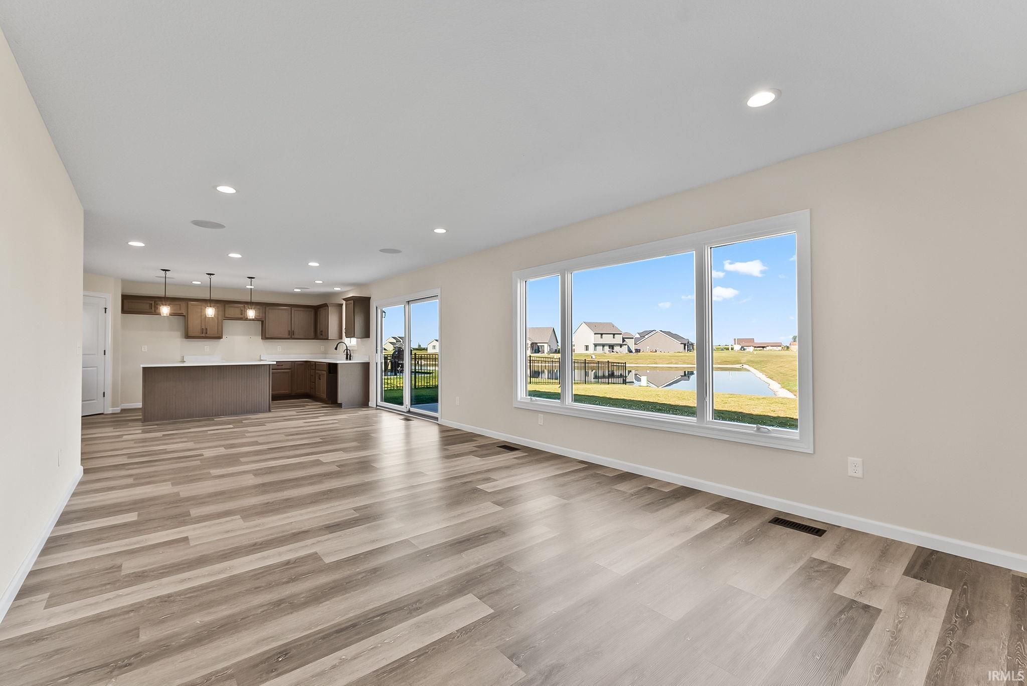Open concept living area featuring wood-finish flooring and recessed lighting