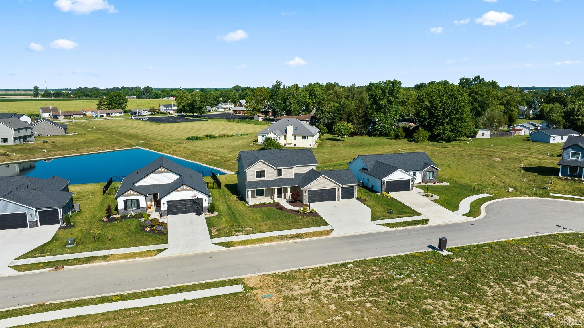 Recently constructed residences featuring a combination of modern and traditional architectural styles, attached garages, and paved driveways