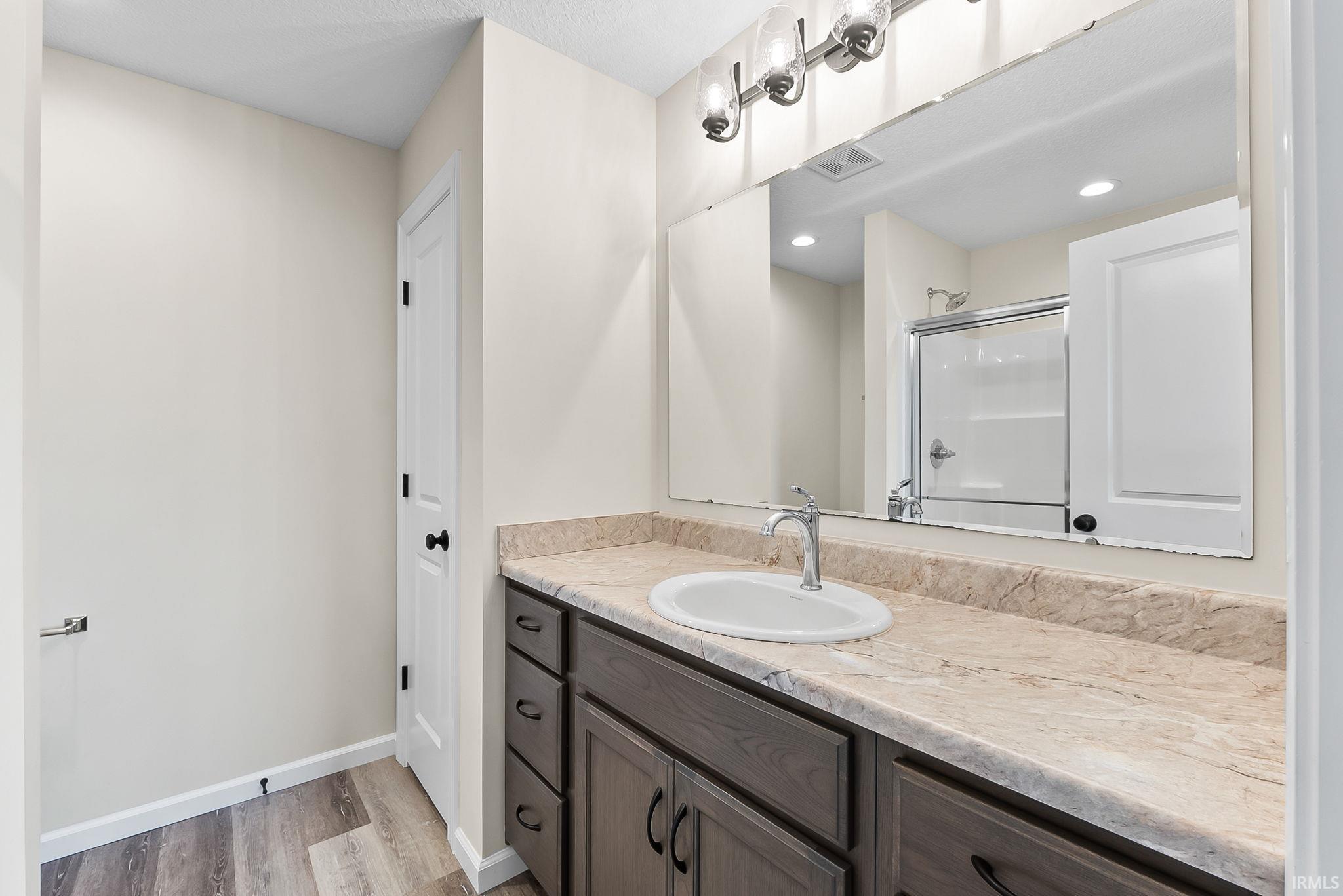 Bathroom vanity with a surface-mounted sink, chrome faucet, and expansive mirror