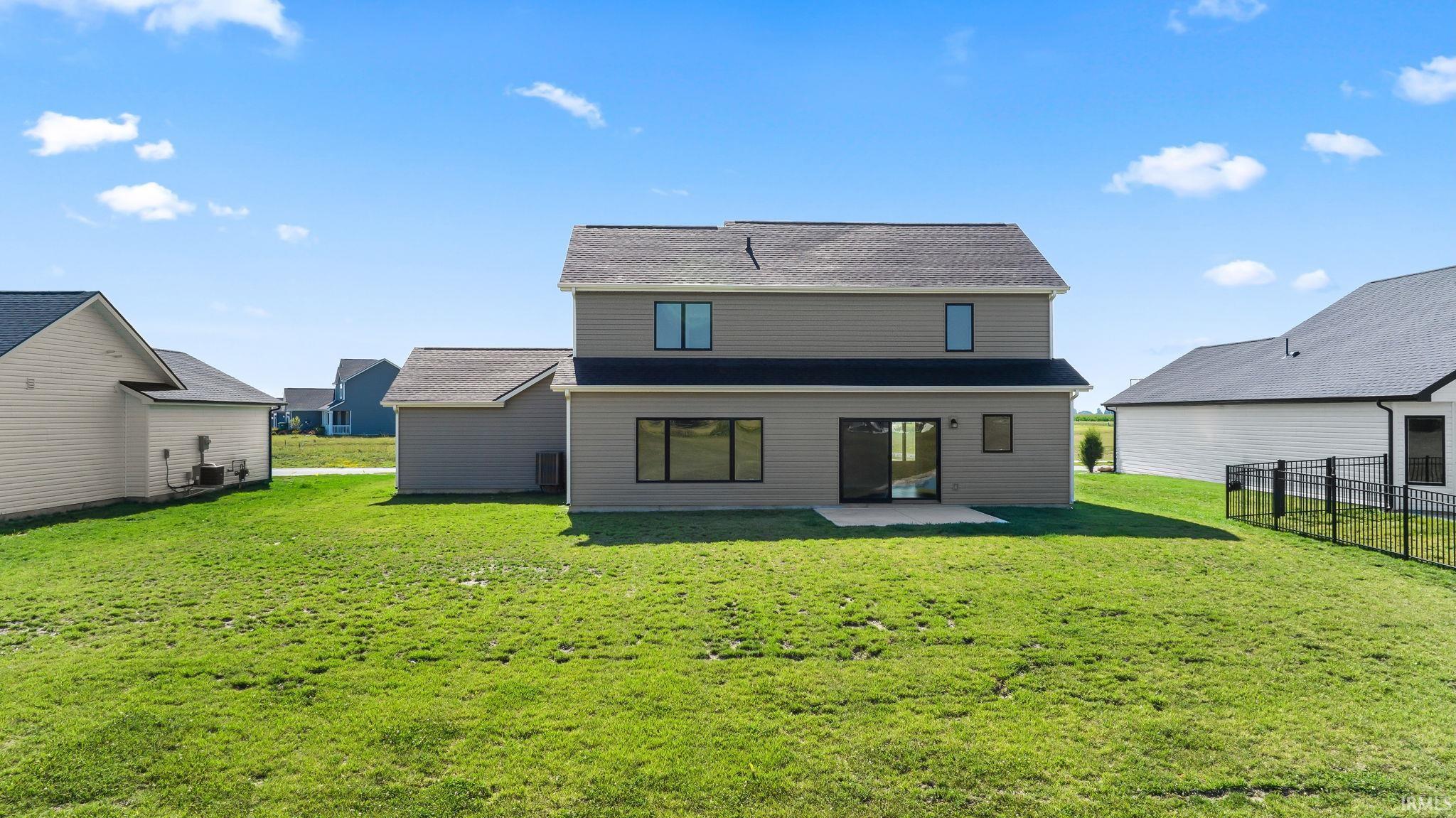 Spacious rear yard with a concrete patio, offering outdoor living space