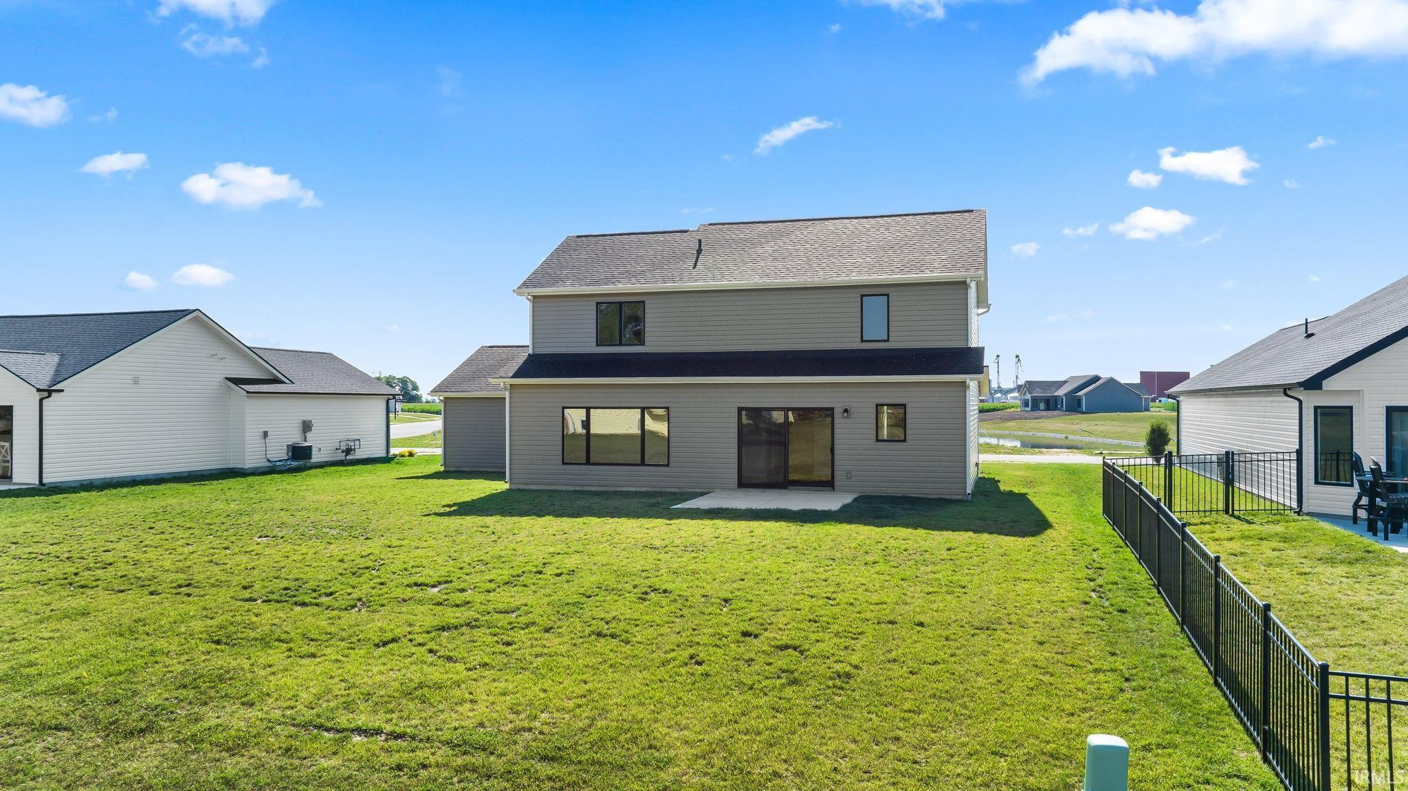 Spacious rear yard with a concrete patio and sliding glass door access