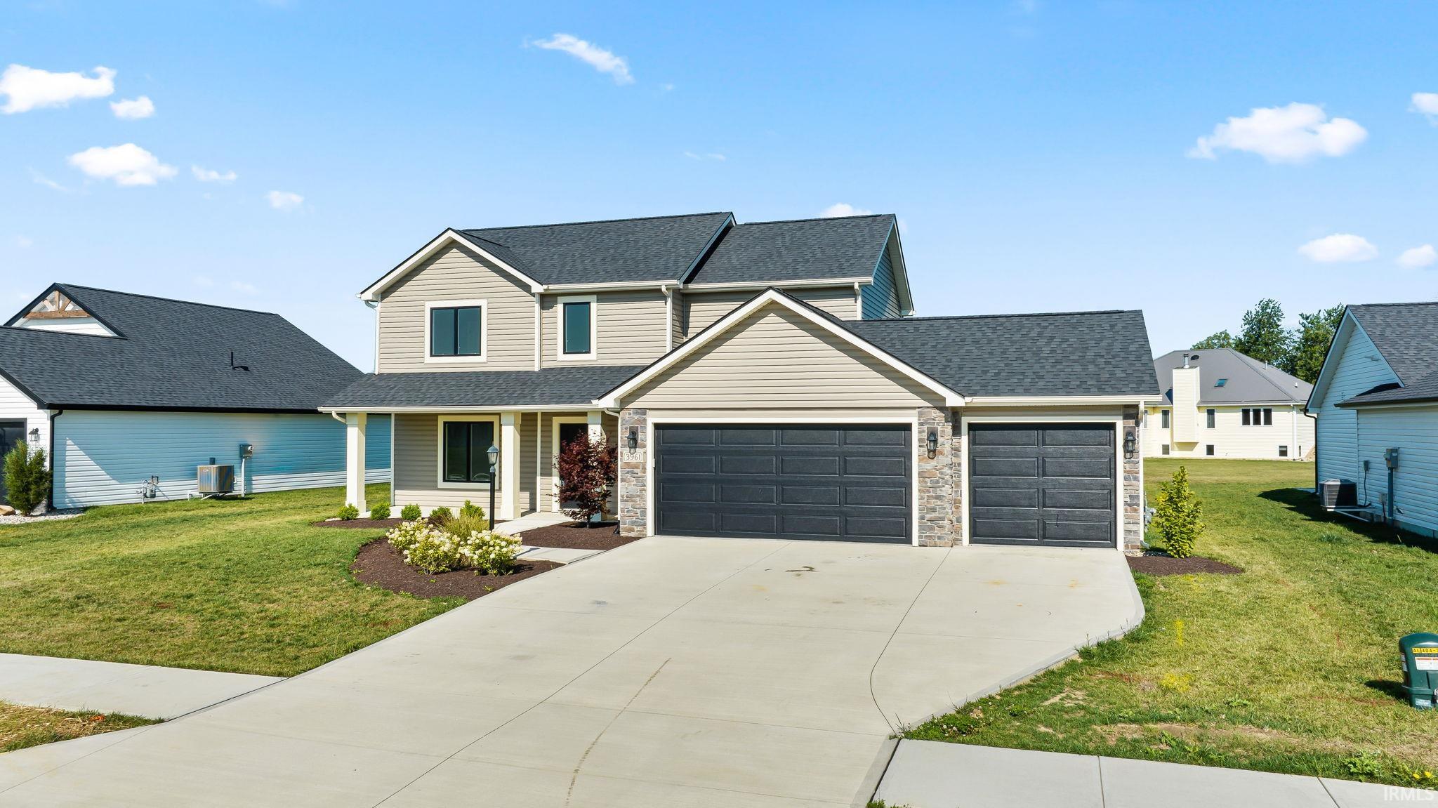 Two-story residence featuring light-colored siding and a dark shingle roof