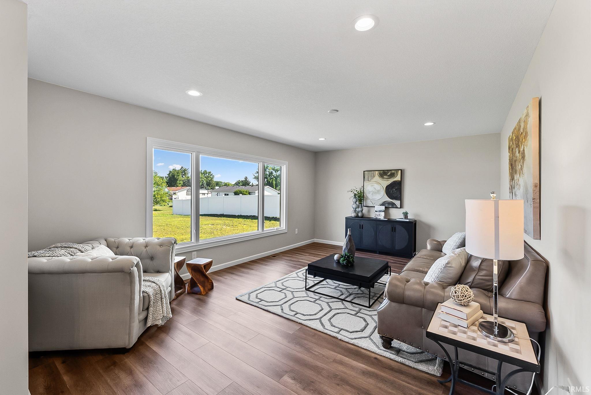 Spacious living area featuring wood-finish flooring, recessed lighting, and a large window offering expansive outdoor views