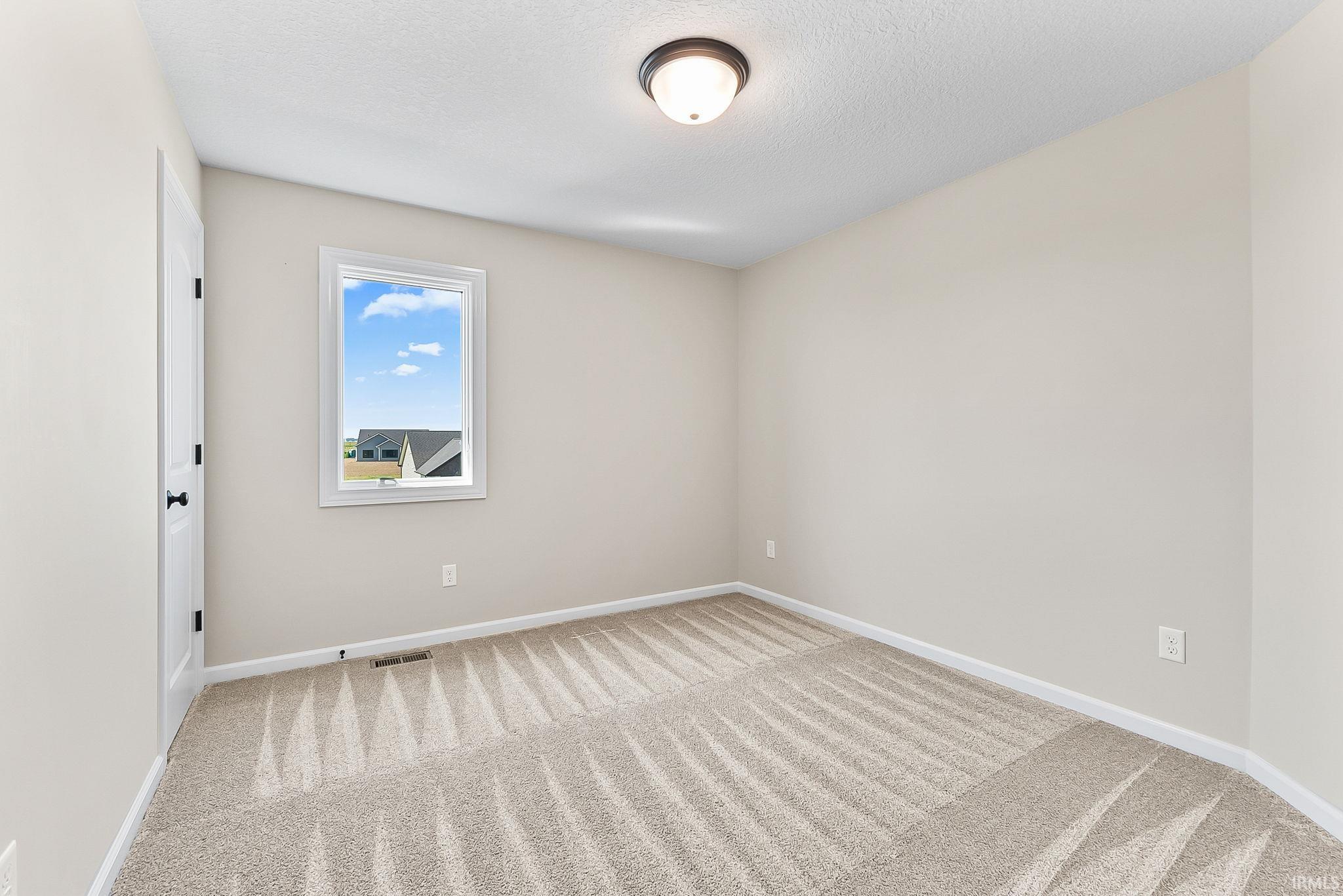Neutral-toned interior with light beige walls and complementing patterned carpeting