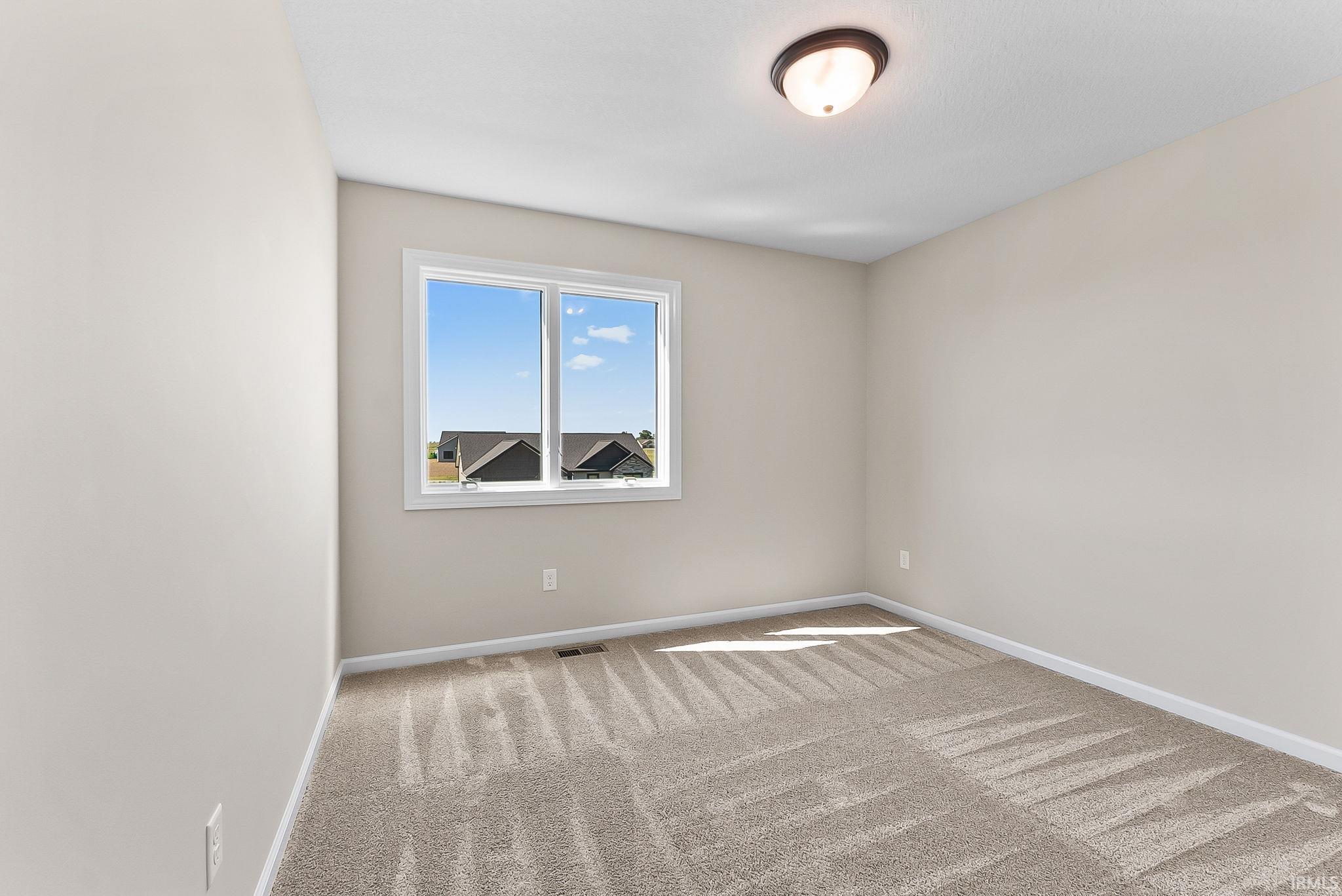 Neutral-toned walls and plush carpet flooring complement a white-framed window