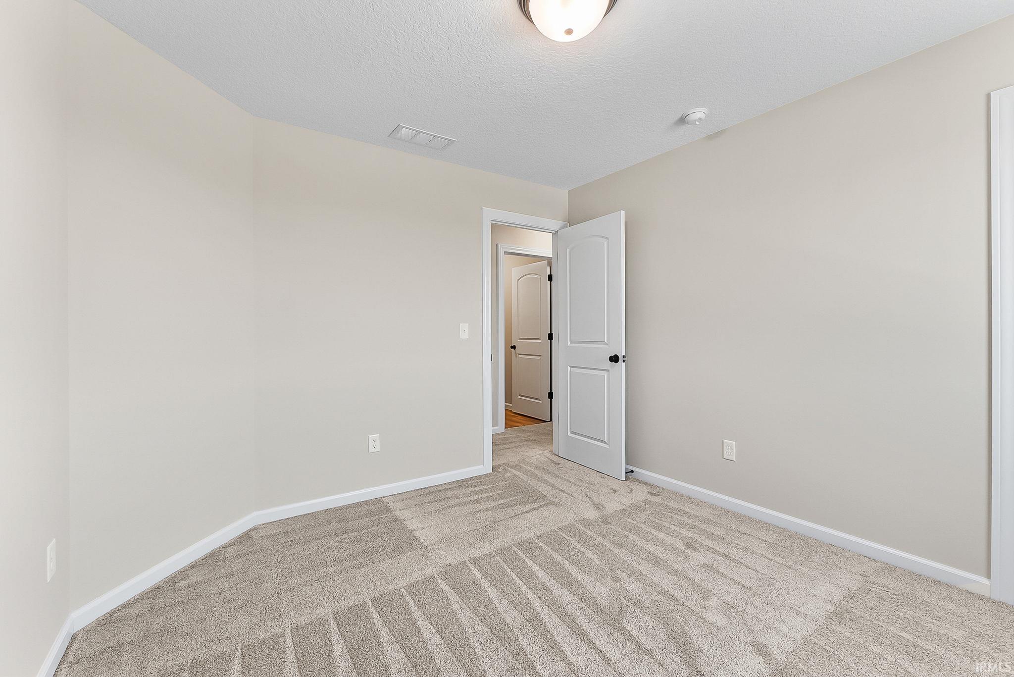 Interior room featuring light gray wall paint and patterned carpeting