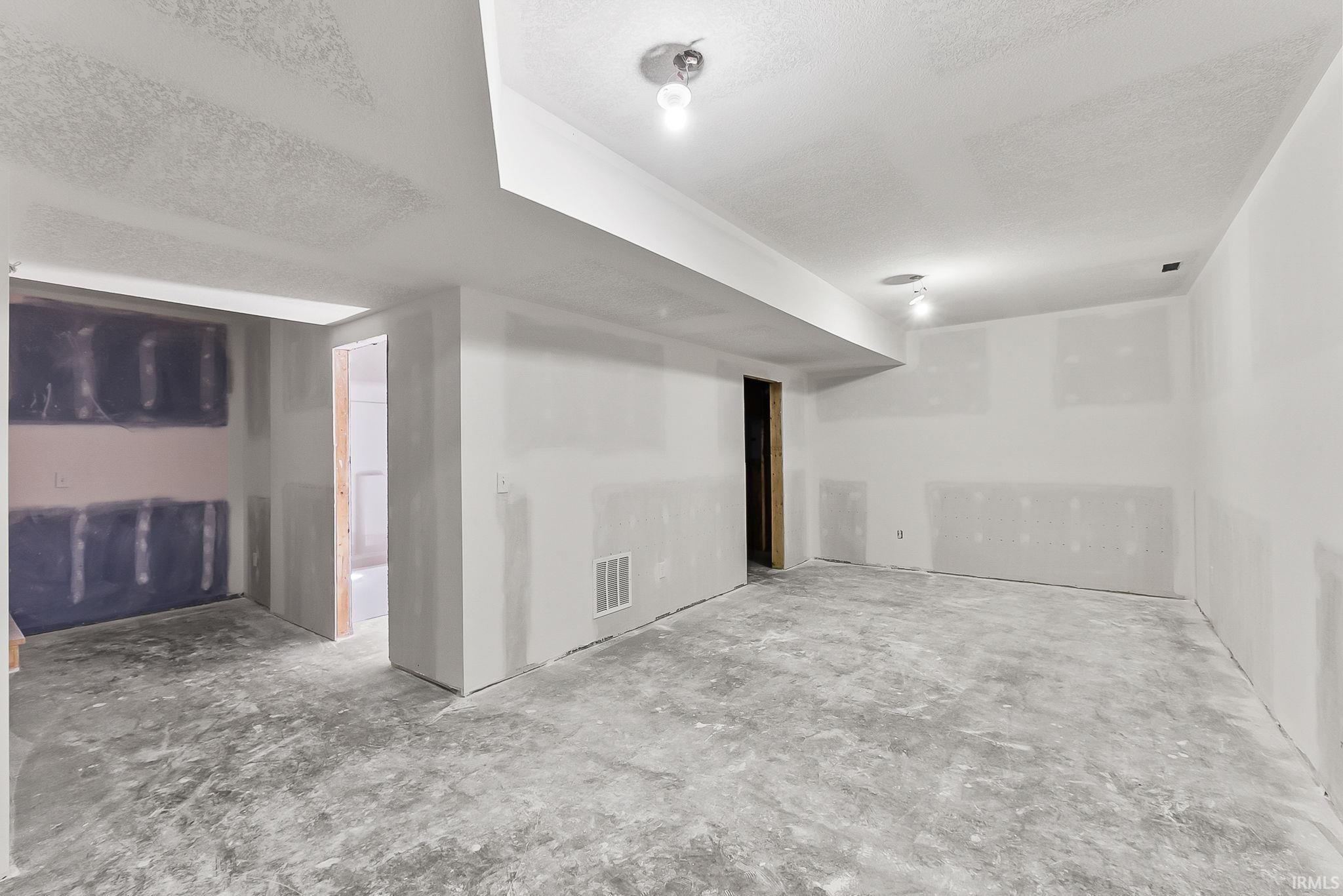 Spacious basement featuring polished concrete flooring, recessed ceiling lighting, and multiple wall outlets