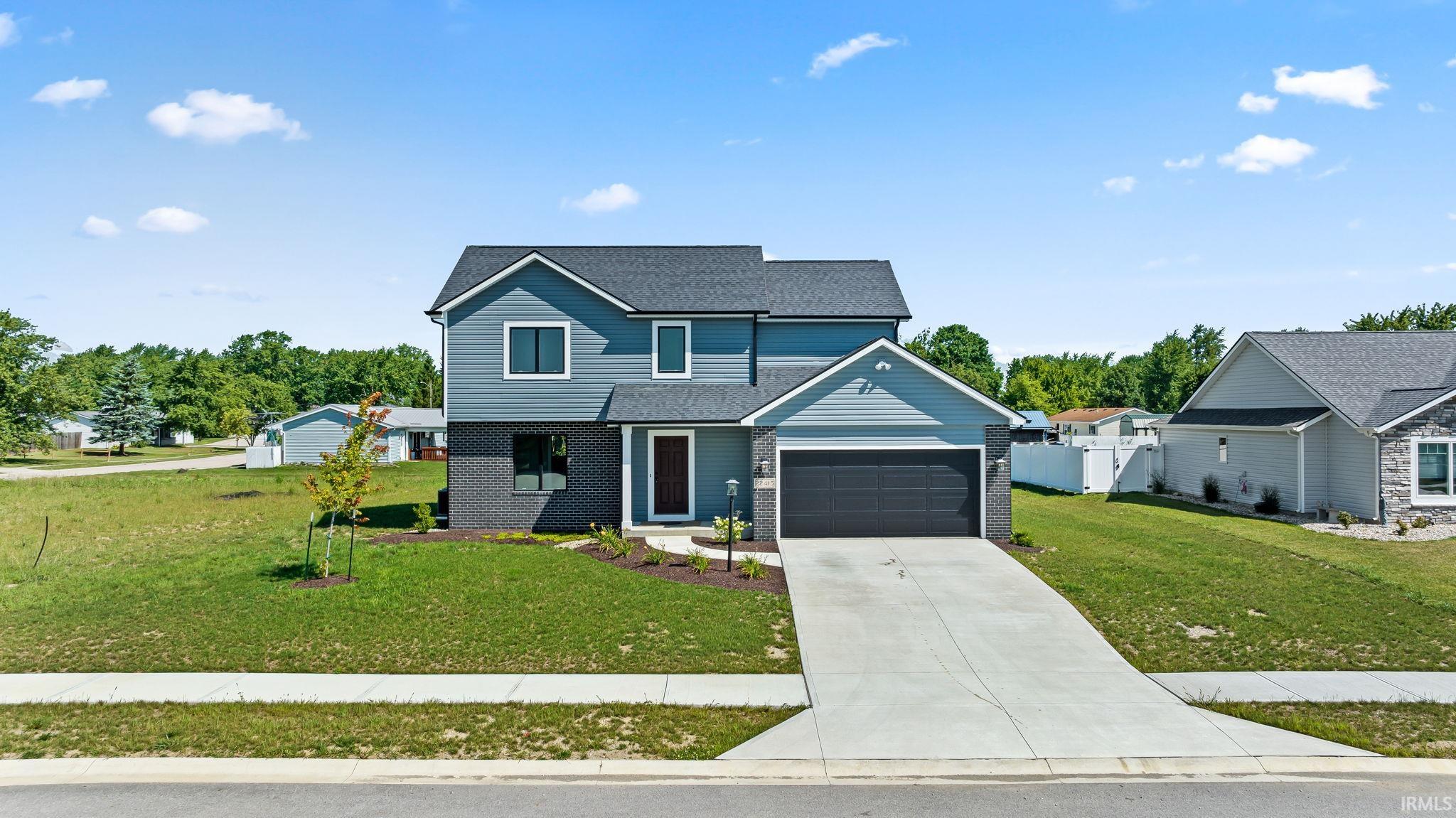 Contemporary two-story residence featuring a dark gray shingle roof and light blue siding