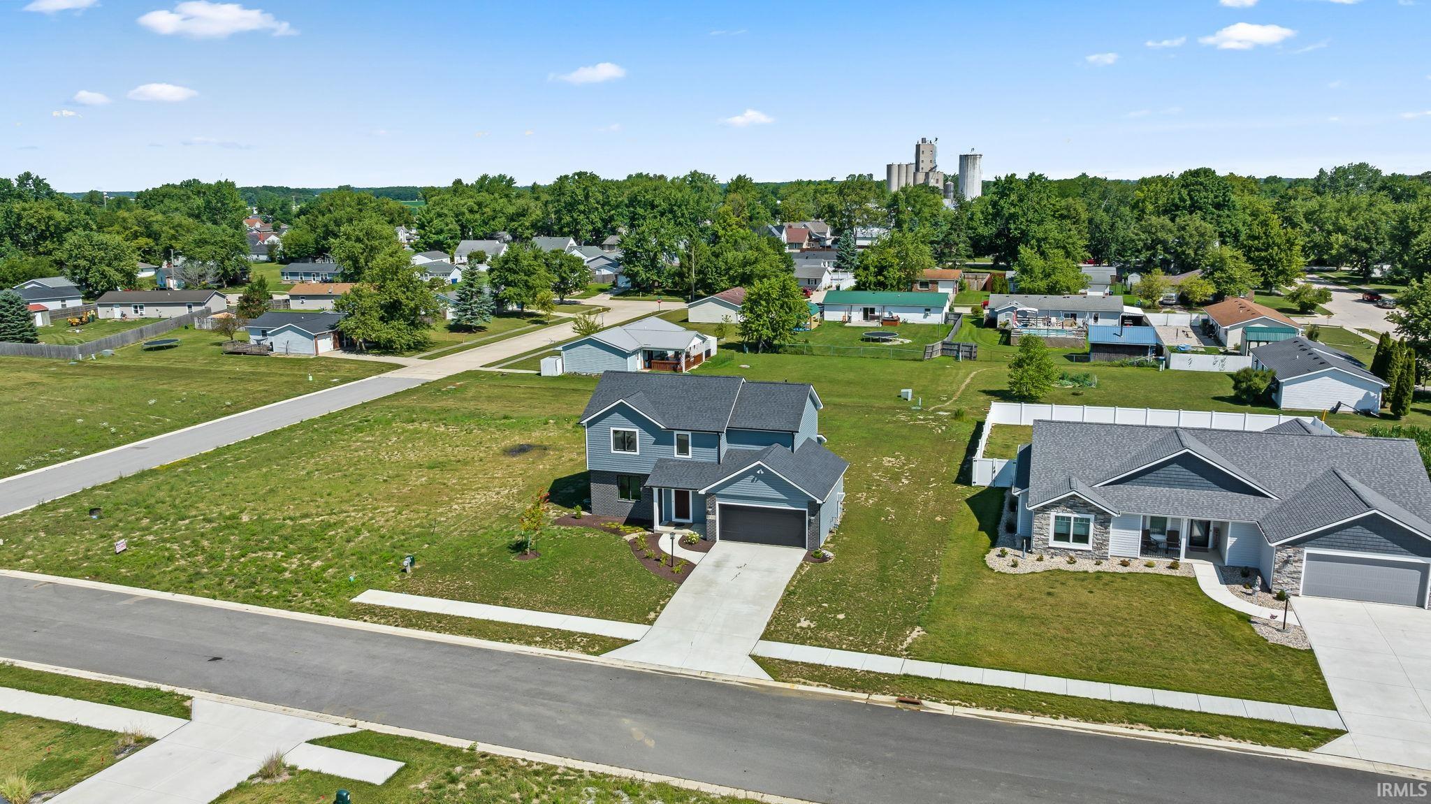 Modern two-story residence situated on an expansive lot featuring a manicured lawn, mature landscaping, and professional hardscaping with defined driveway approach
