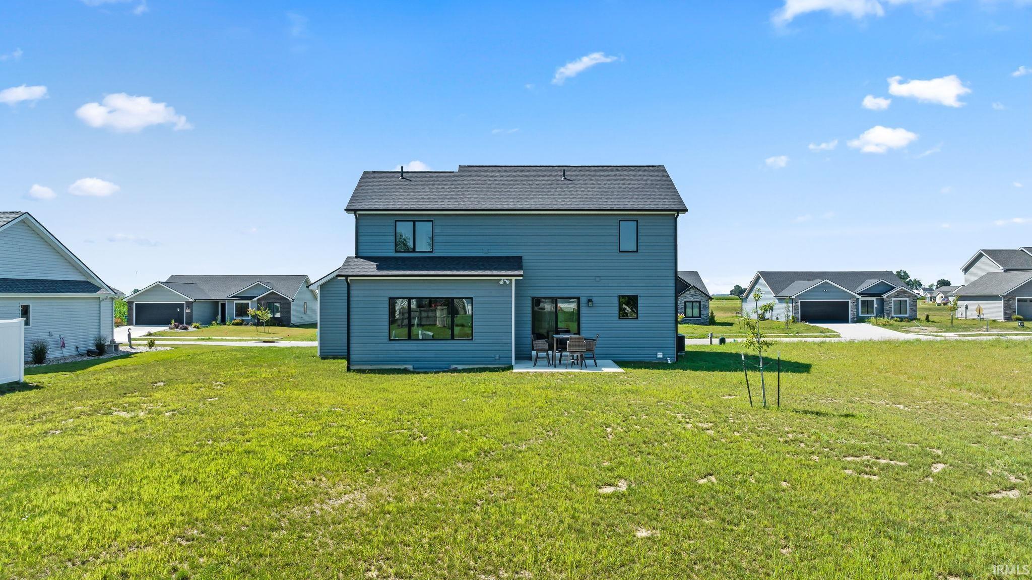 Rear exterior showcasing a two-story residence with gray siding and a dark shingle roof
