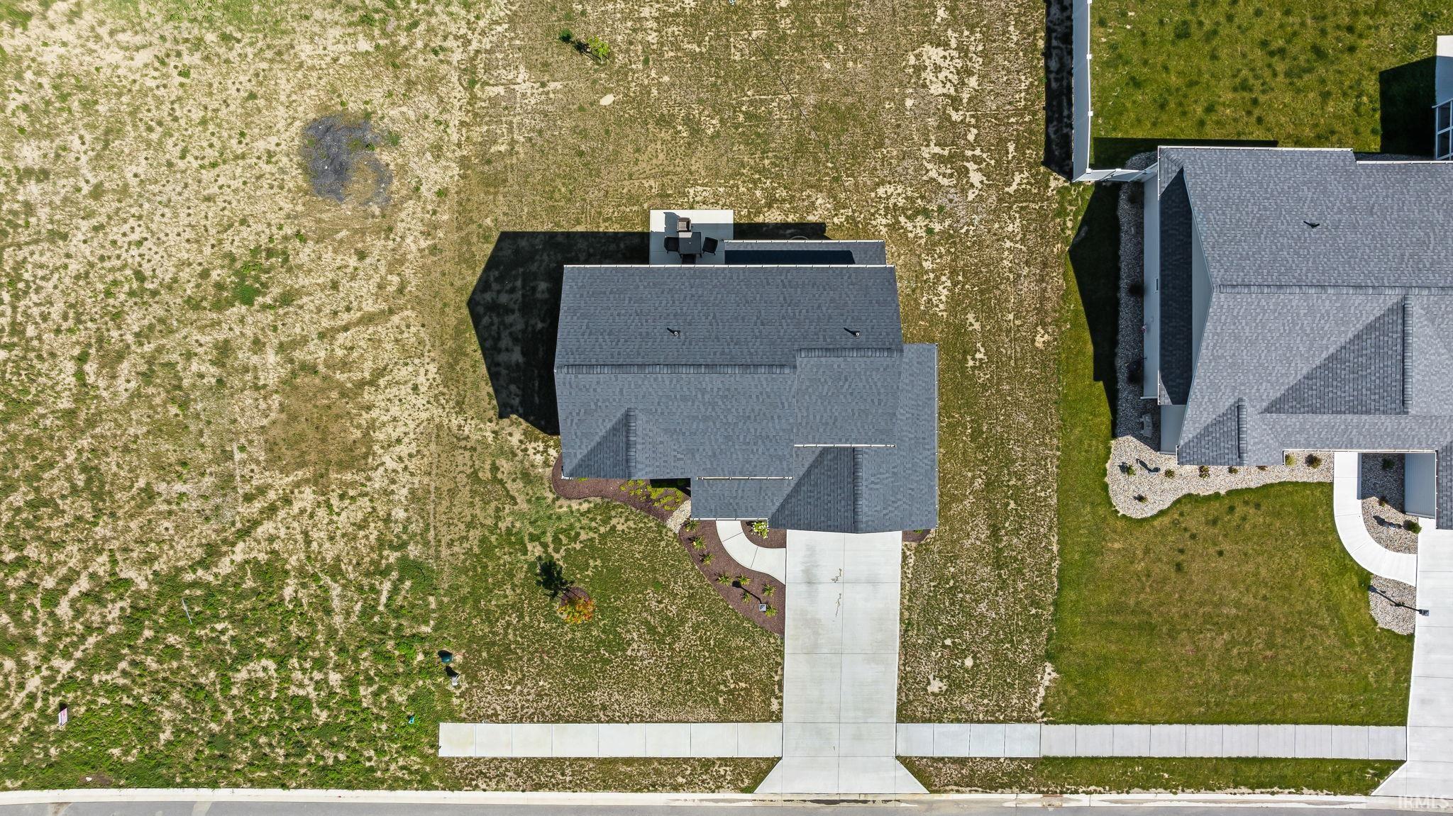 Contemporary residential property with a dark shingle roof and a concrete driveway