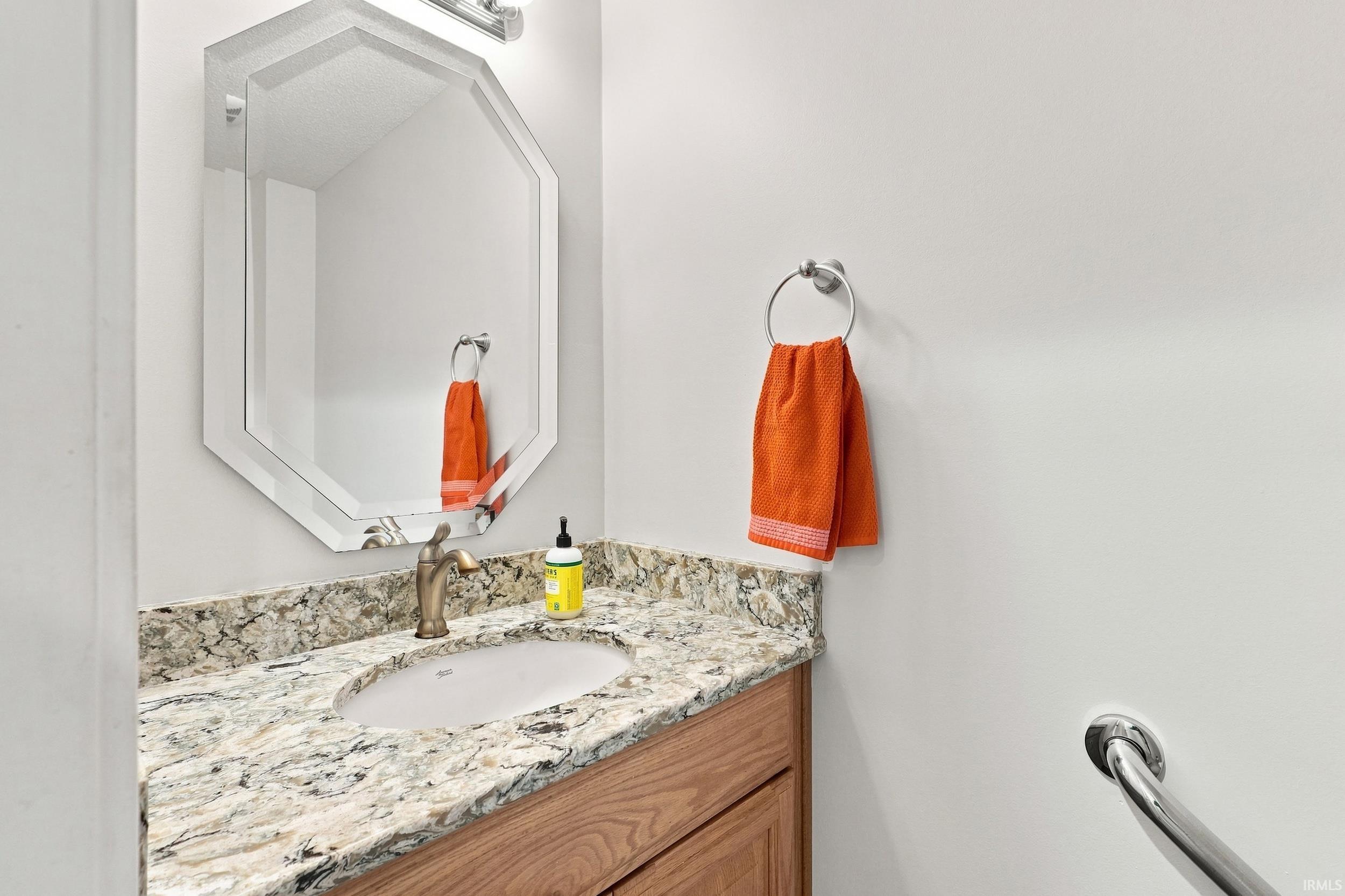 Vanity with a granite countertop and an undermount sink